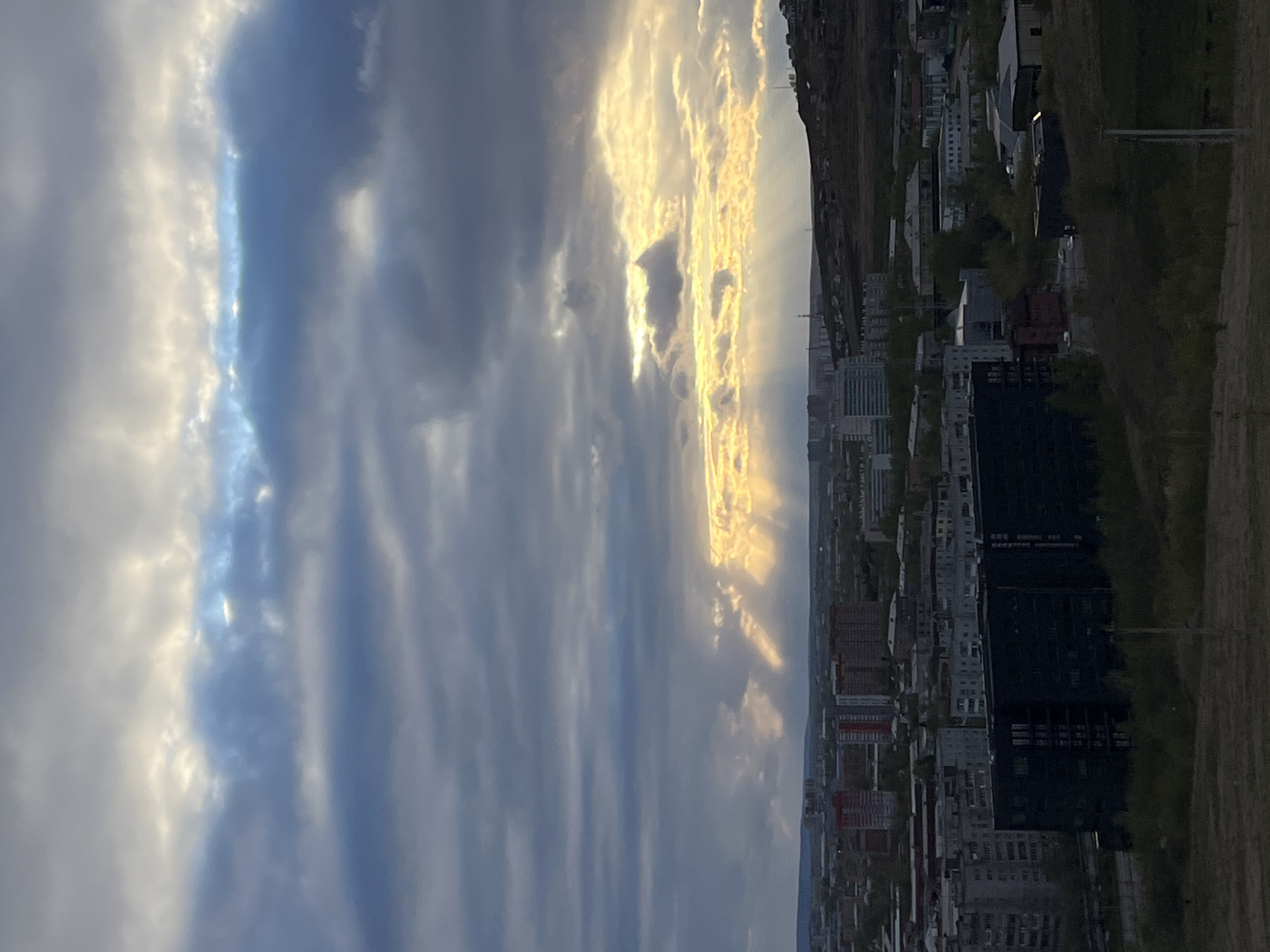 Dramatic sky with sun rays observed over Krasnoyarsk cityscape