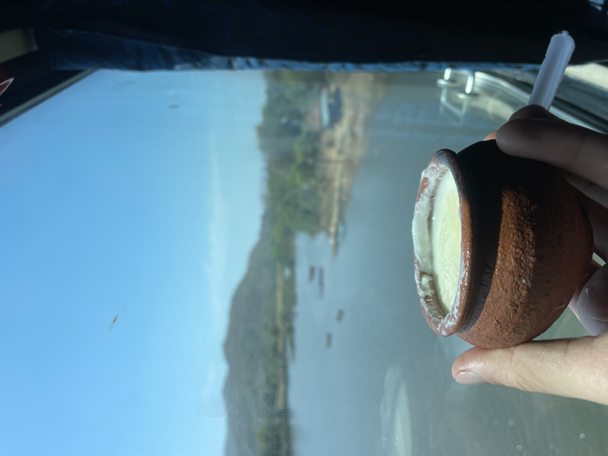 Person enjoys yogurt from clay pot in Dasgaon