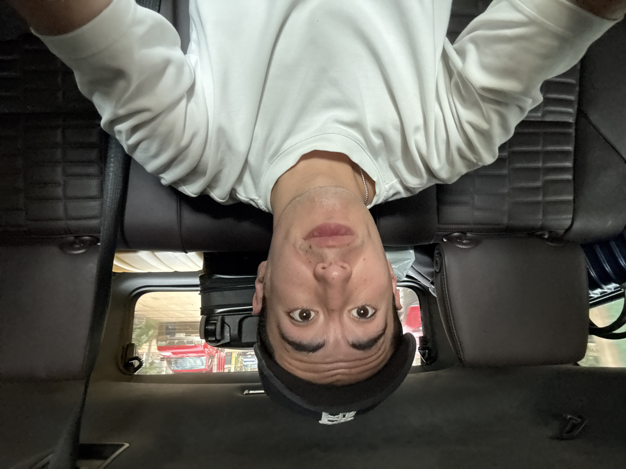 Man photographed lying upside down in vehicle backseat