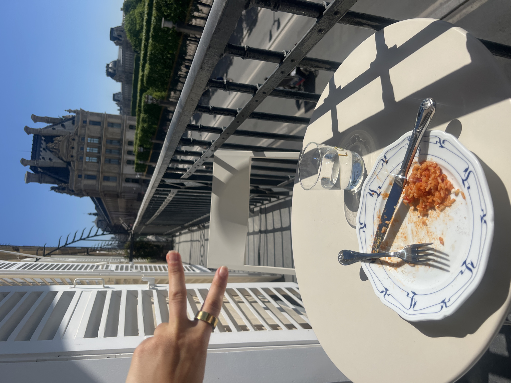 Woman enjoys sunny balcony lunch overlooking Louvre in Paris