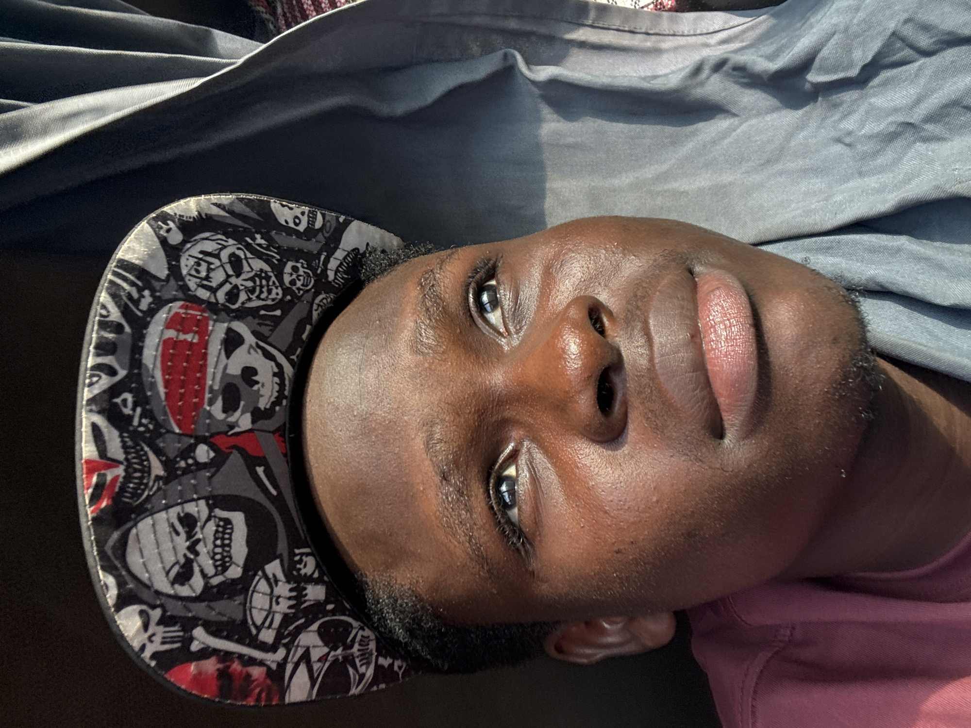 Portrait shot in Owa, Nigeria, cap and upward gaze.