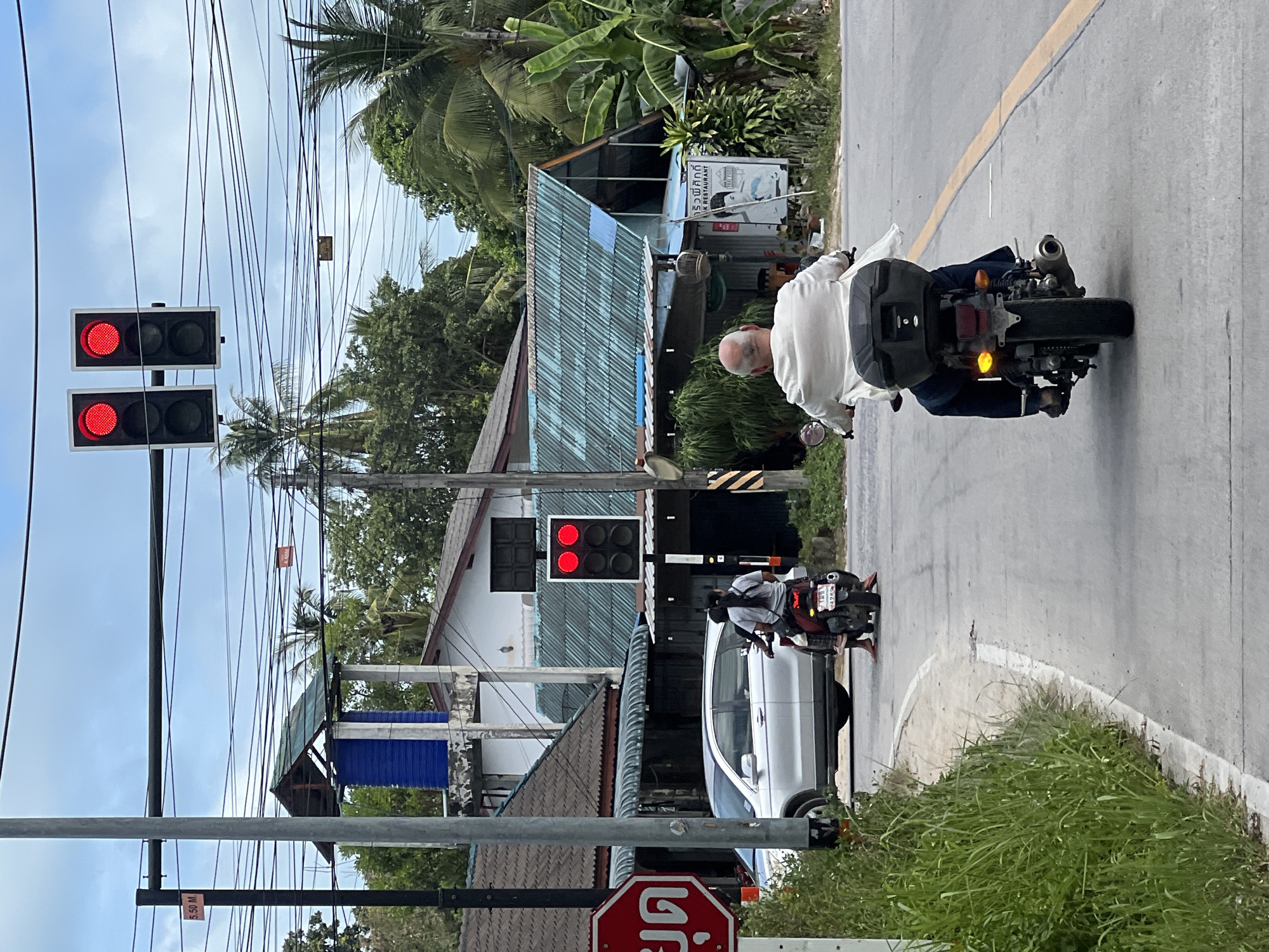 Scooters rolling through Ko Pha Ngan streets on a cloudy afternoon