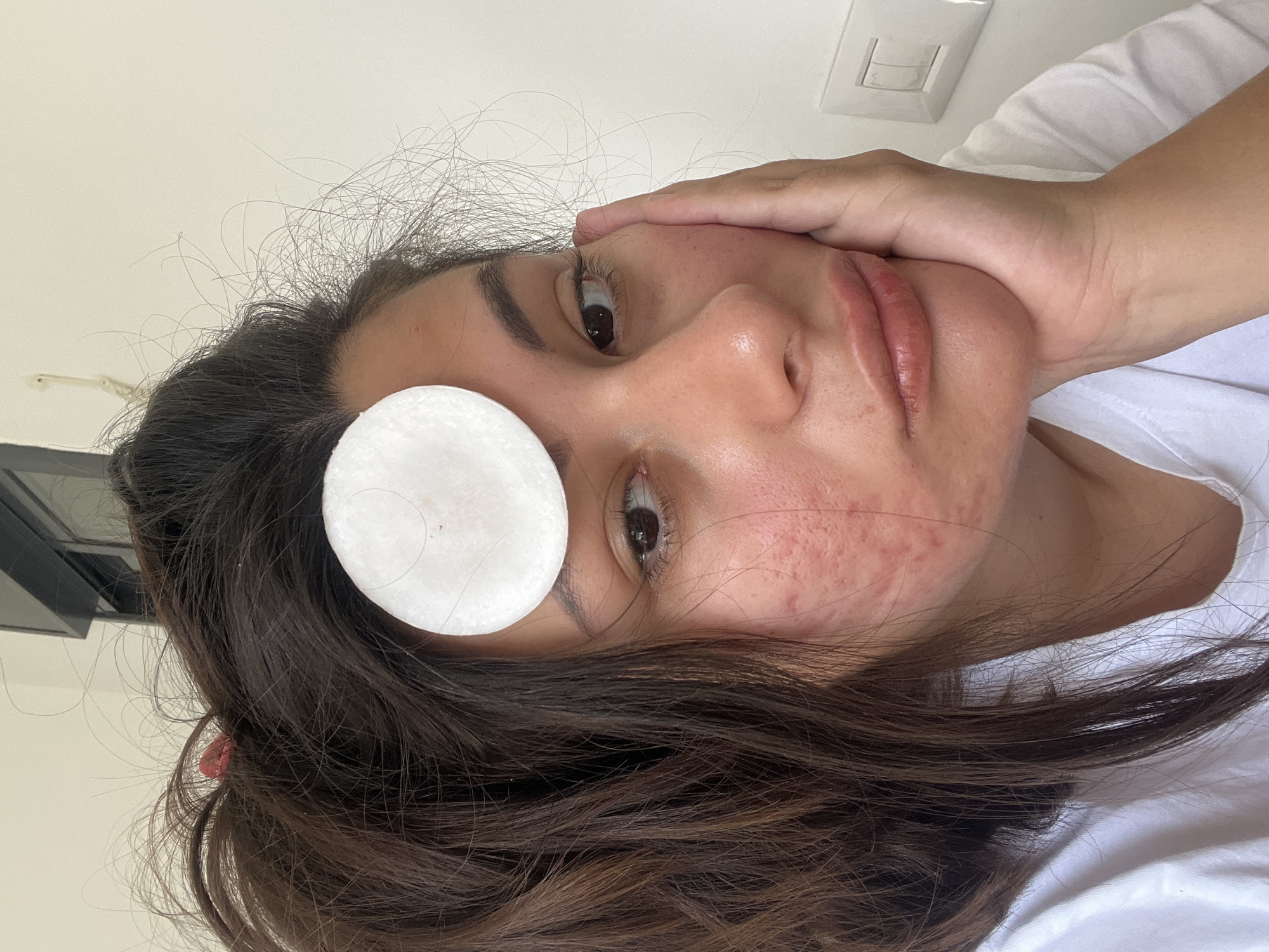 Person applies cotton pad during morning skincare routine in Kiryat Bialik