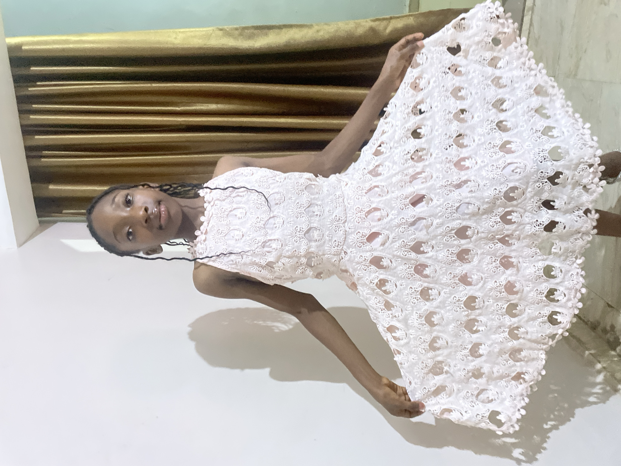 Woman poses with white lace dress in Jos home