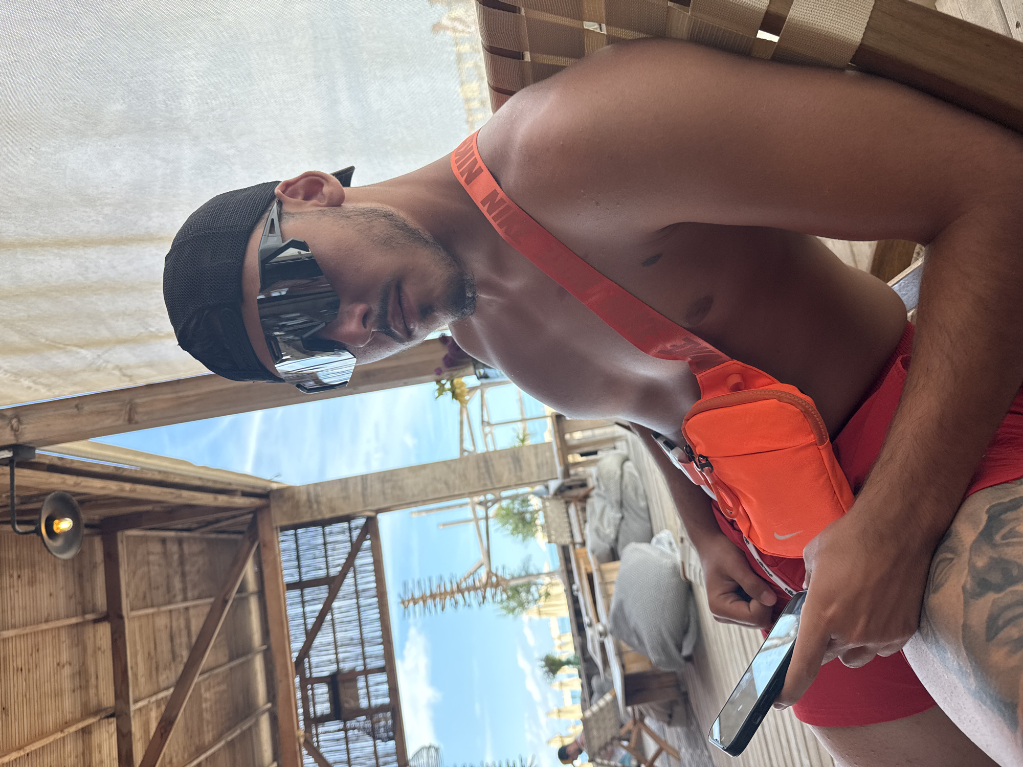 Lounging beachside in Sozopol with reflective shades and fanny pack