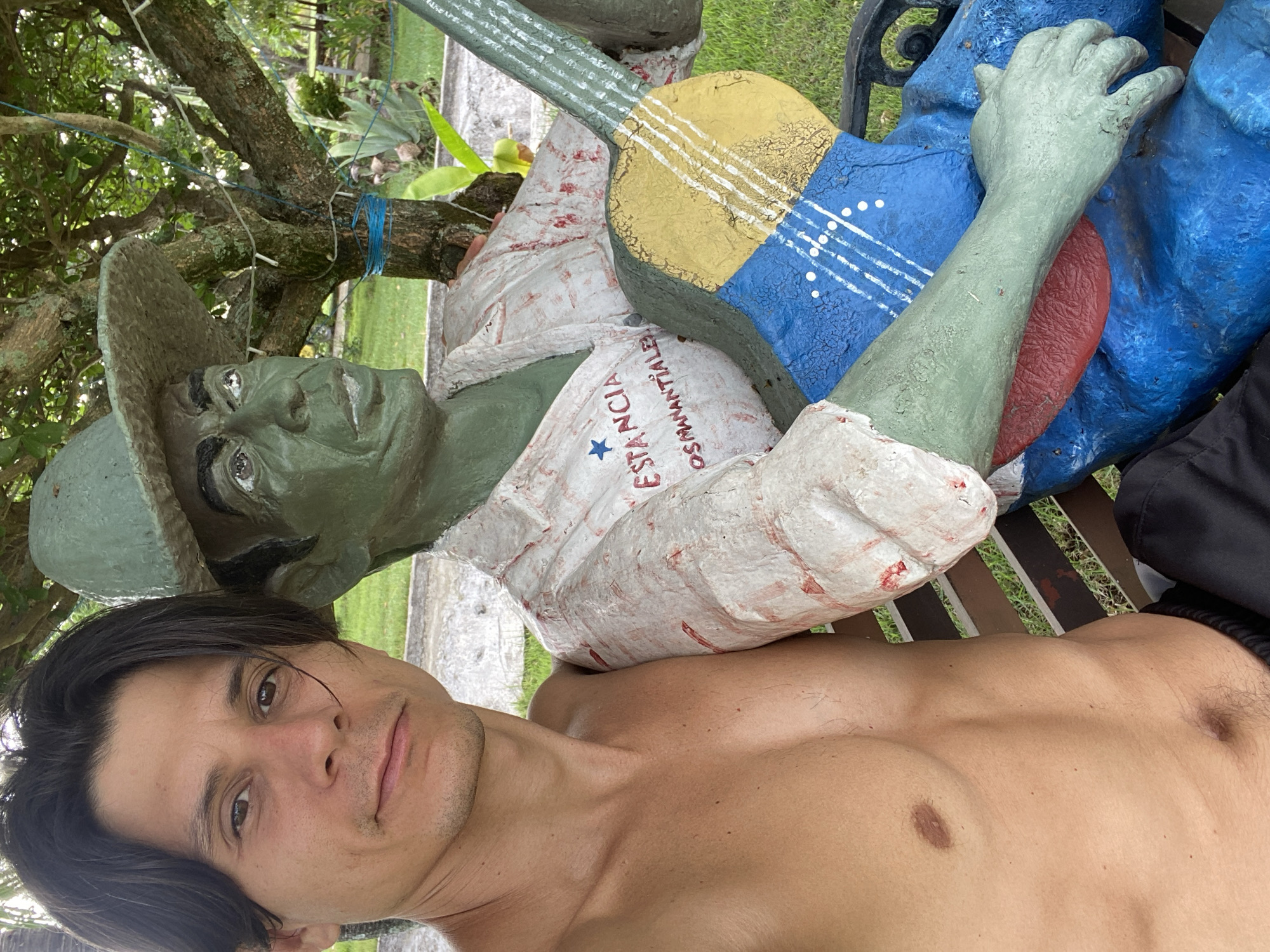 Man takes selfie with statue in Vallecito, Venezuela