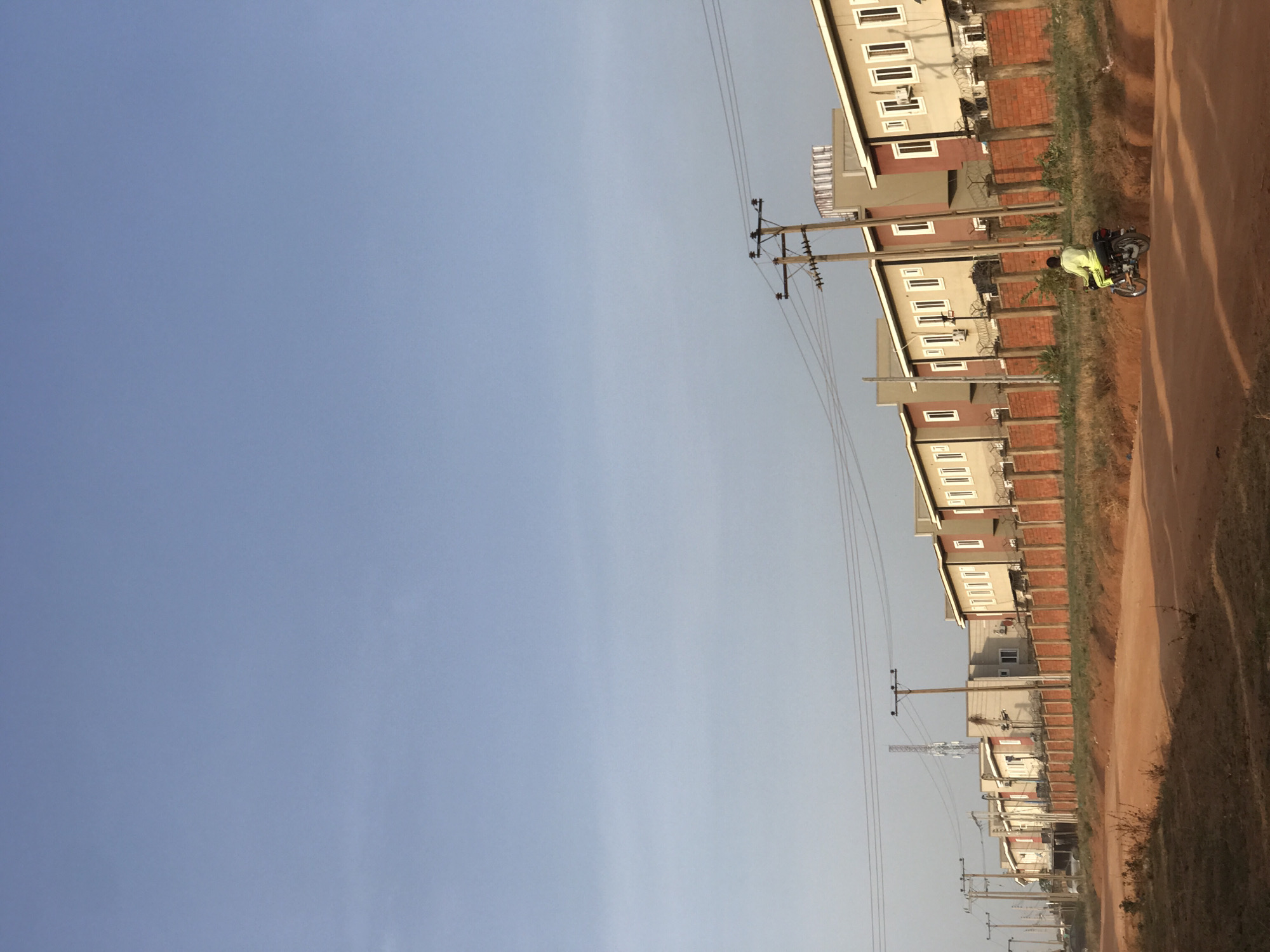 Morning street life documented on dirt road in Abuja