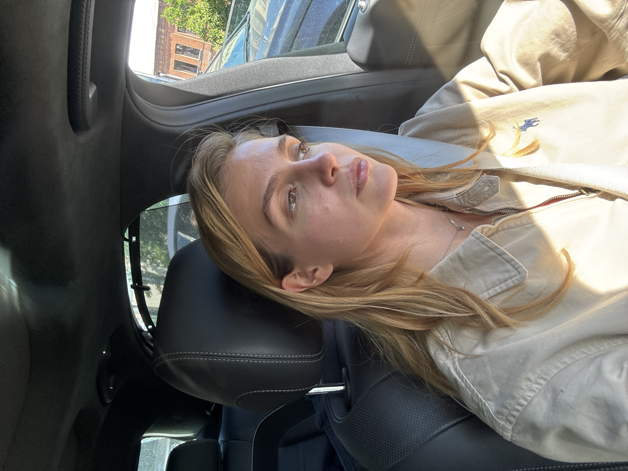 Woman rests in car during bright sunny afternoon