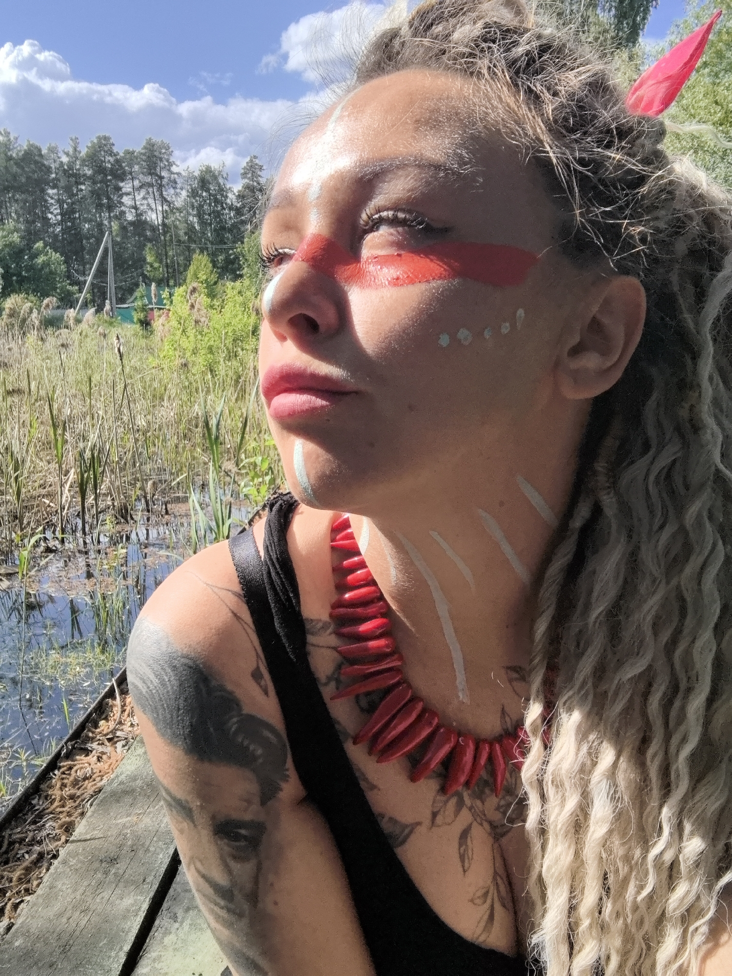 Woman in tribal face paint photographed repeatedly in rural Russia