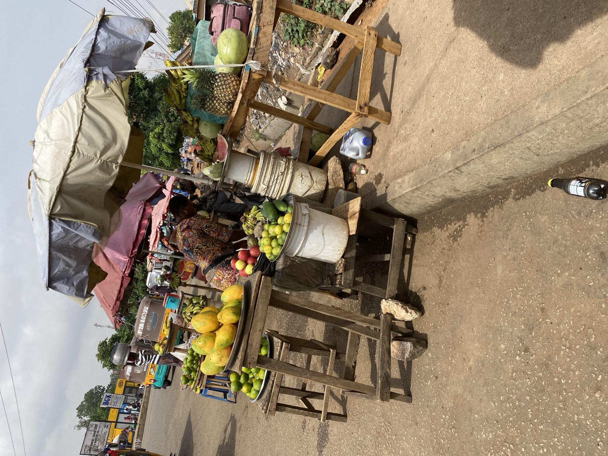 Street vendors sell fresh produce at Bukuru market