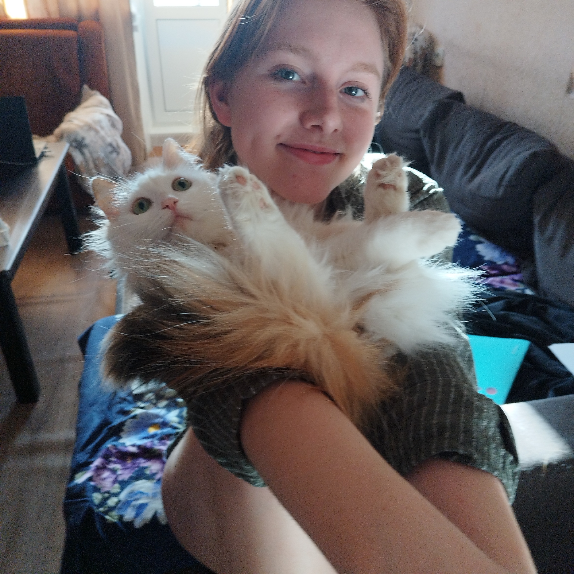 Woman poses with white cat in Yekaterinburg apartment