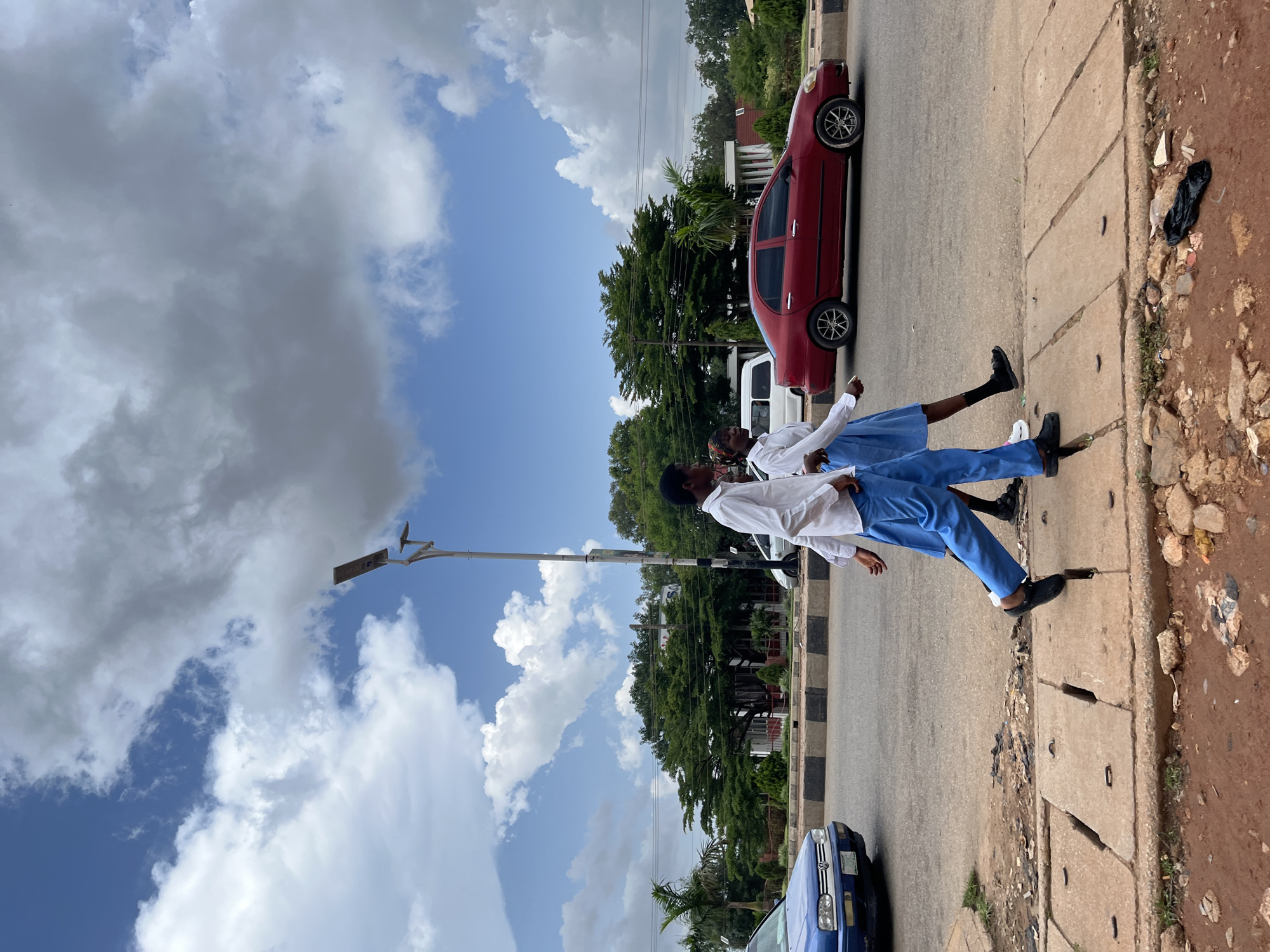 Busy afternoon streets in Jos, Nigeria, with school groups and street traffic