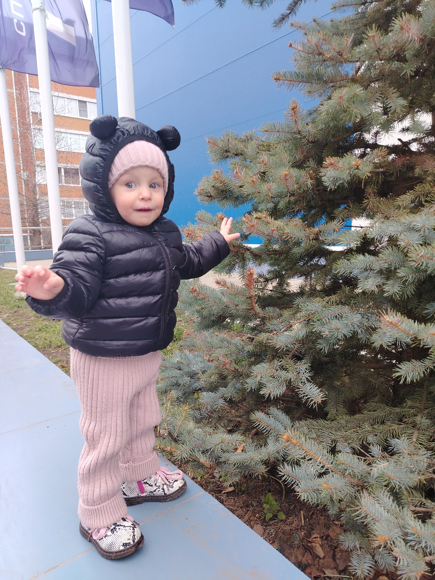Toddler in bear-eared jacket photographed outdoors in Chaikovsky