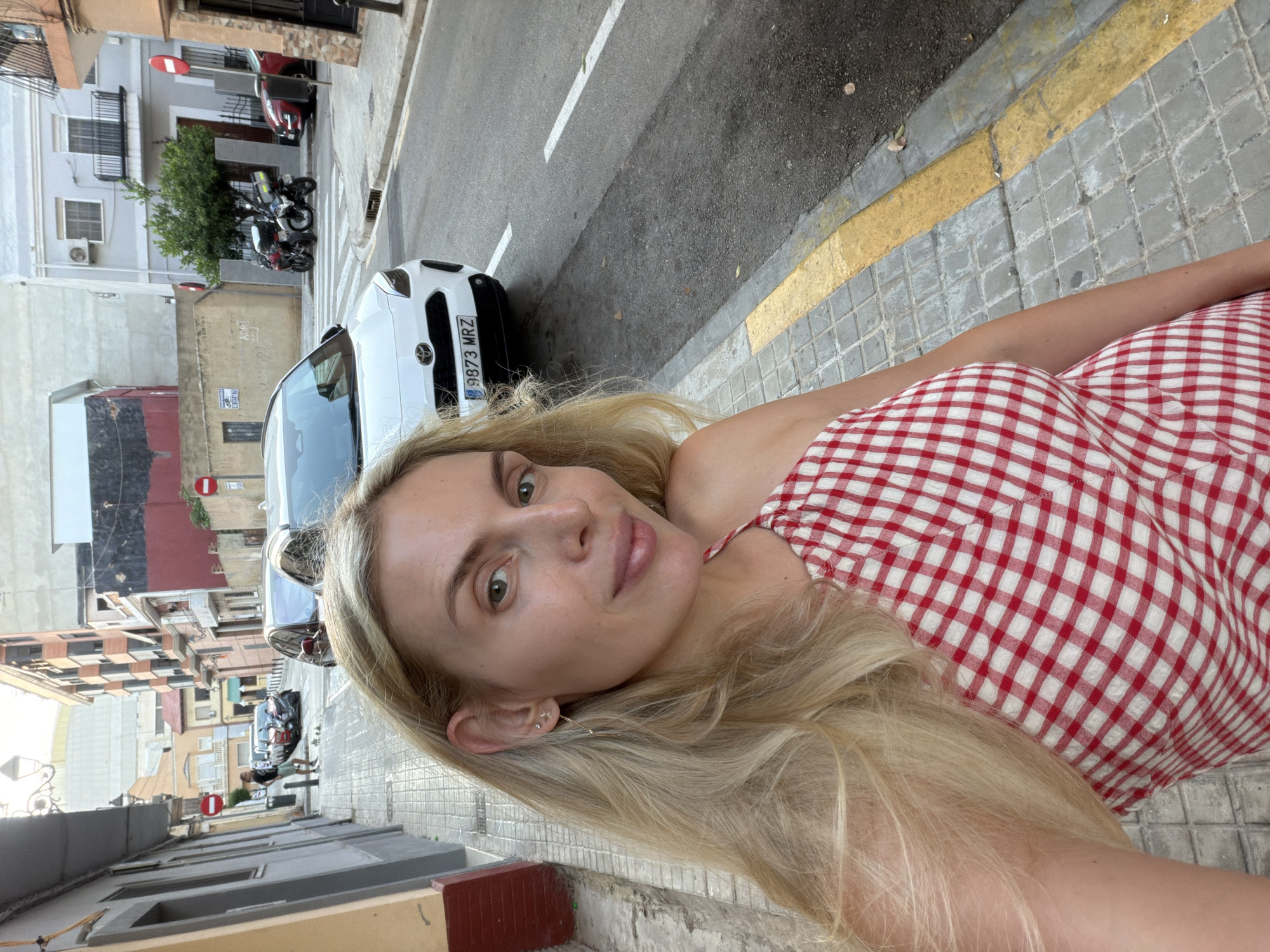 Selfies and street photos along a Valencia sidewalk at dusk