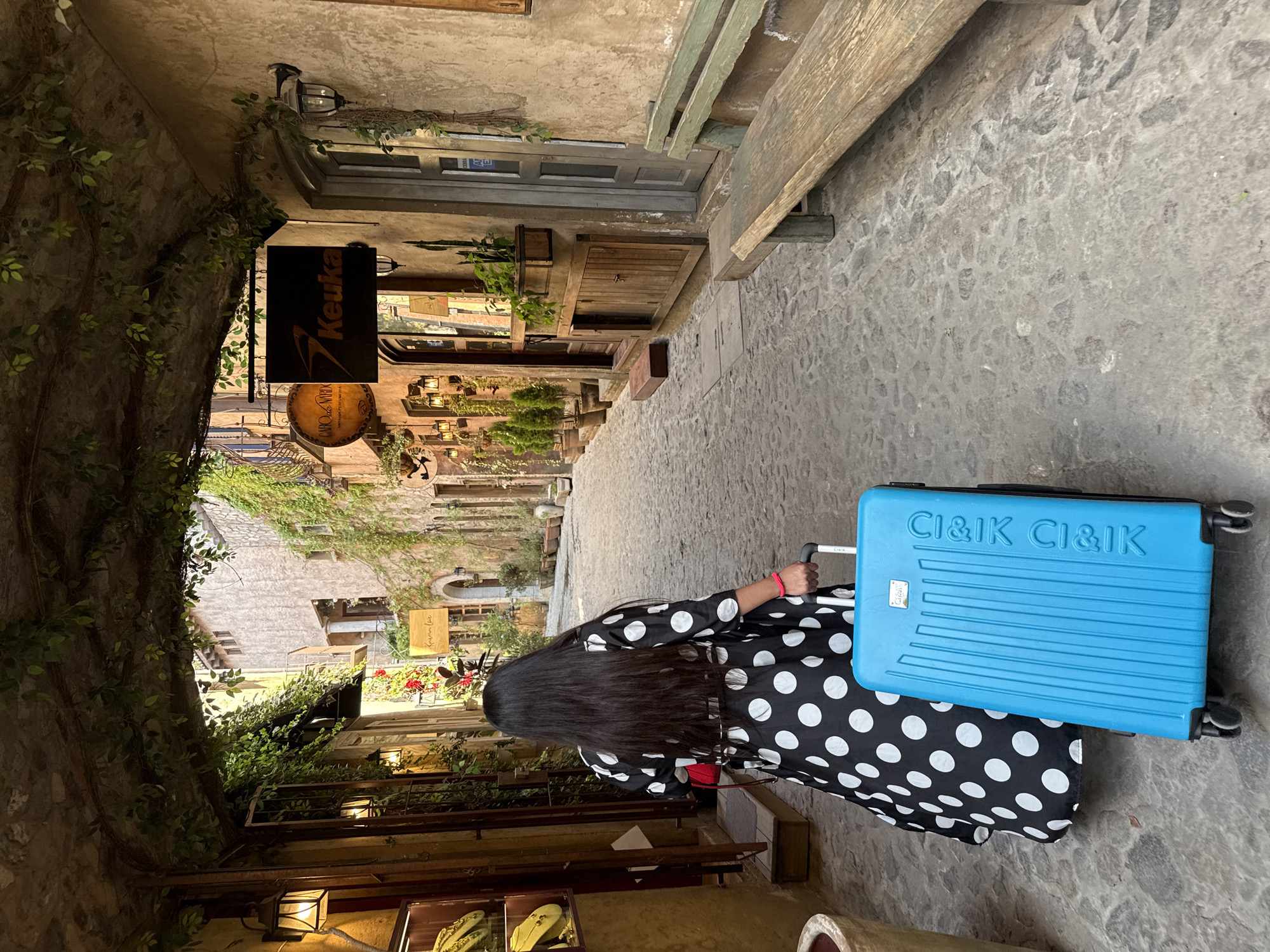 Woman with suitcase walks historic streets in Domingo Arenas