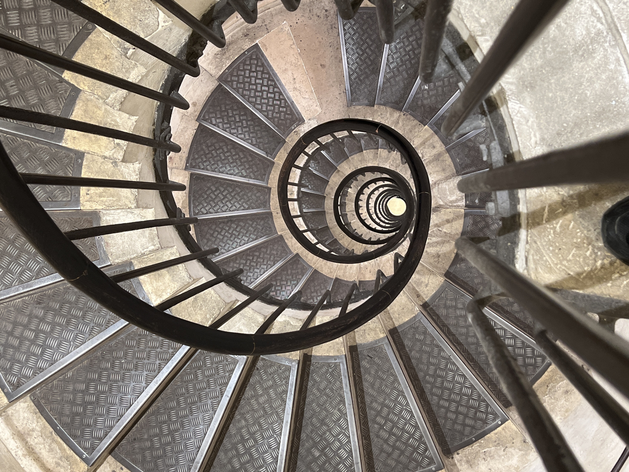 Woman photographed smiling on spiral staircase in Paris