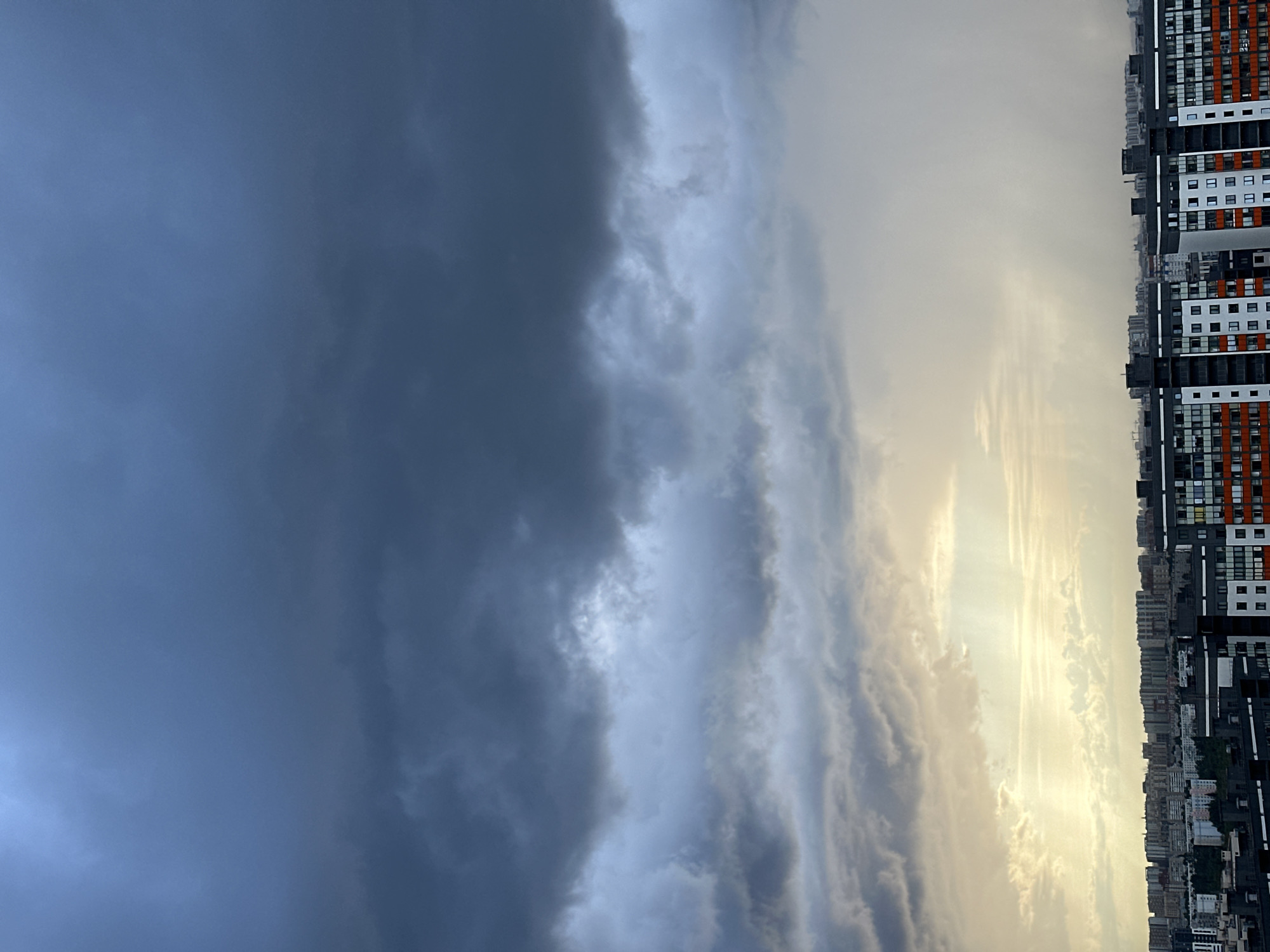 Storm clouds close in over city and forest