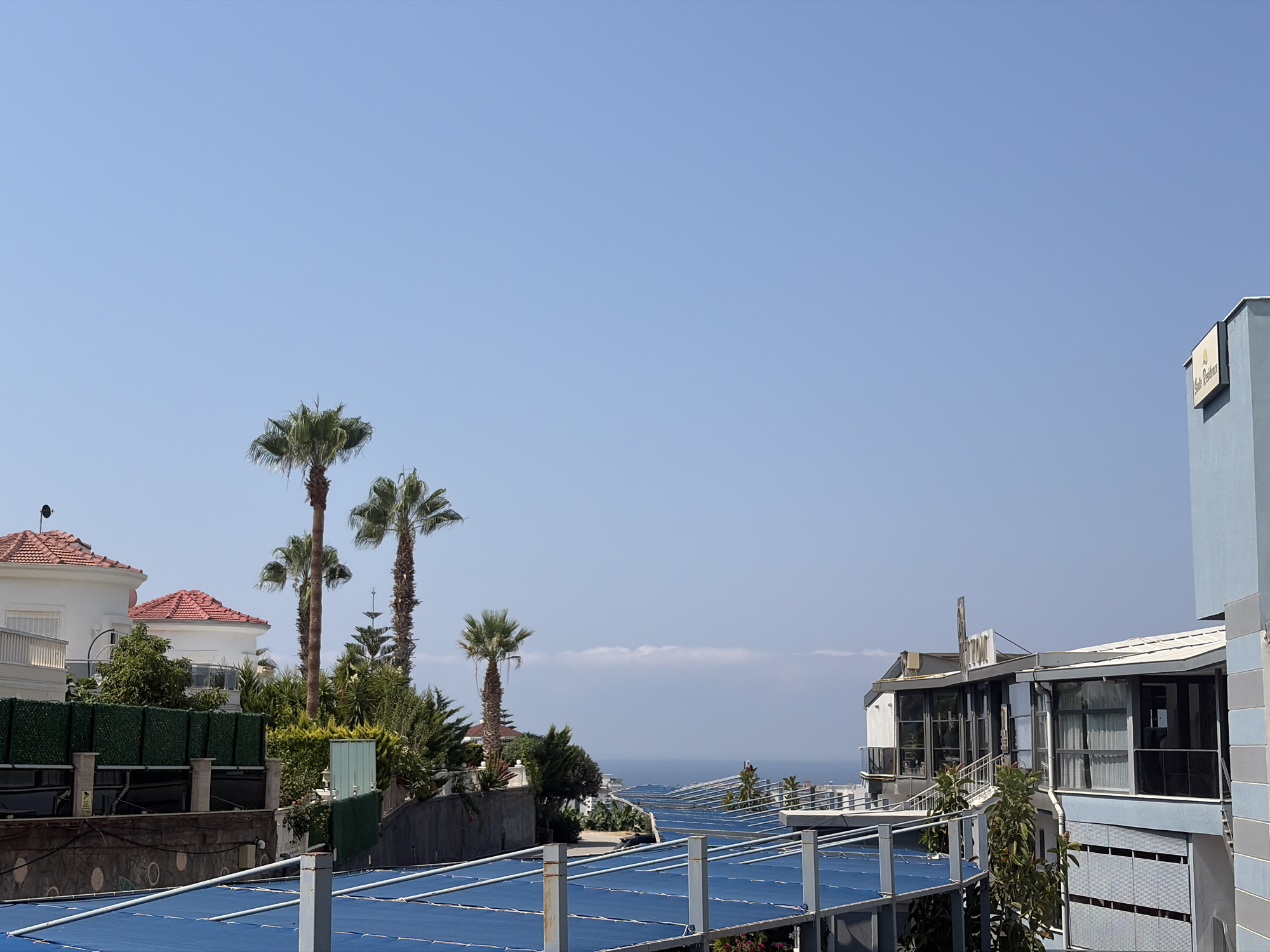 Blue tarp structure meets open sky on the Alanya coast