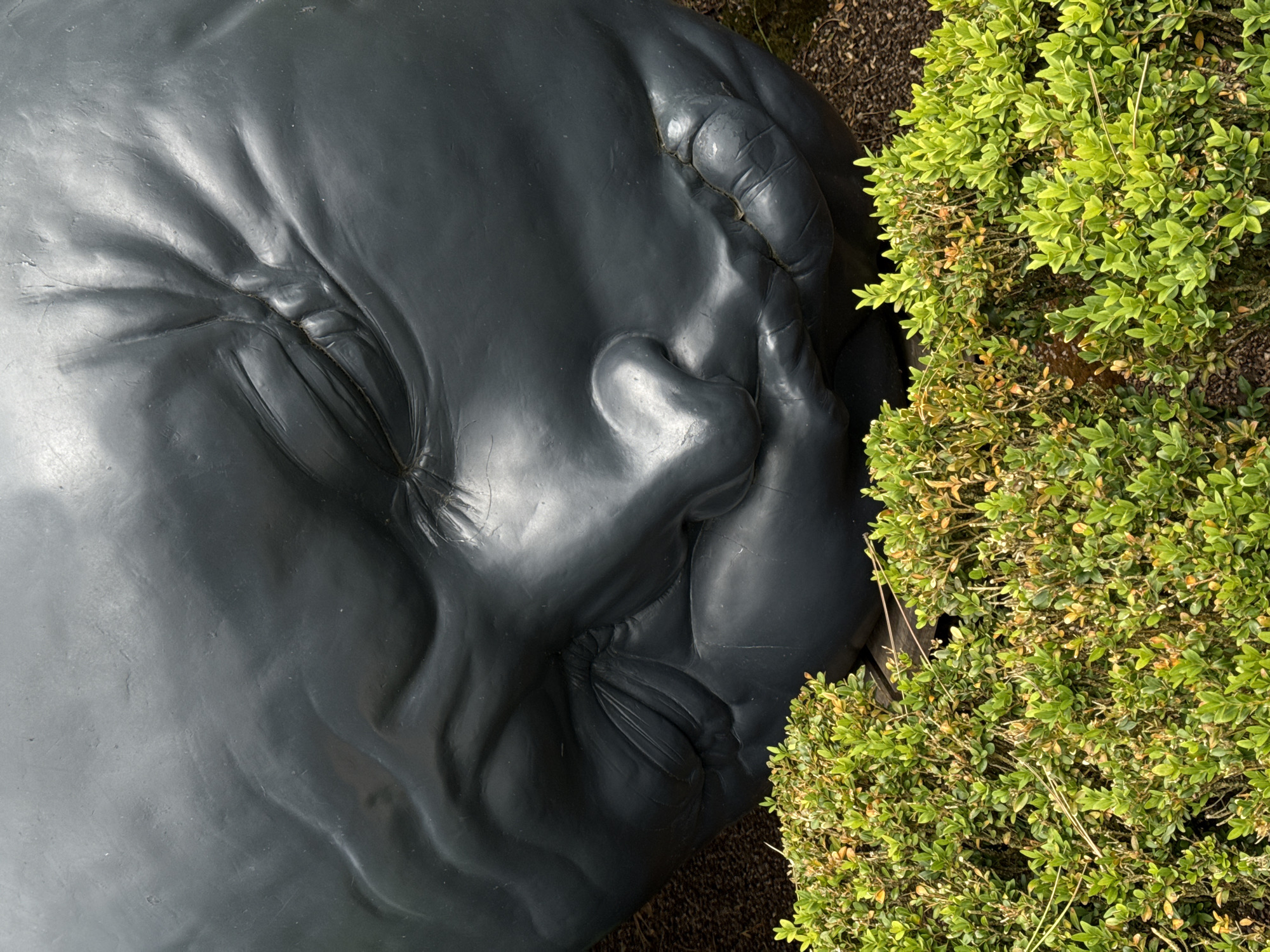 Sculptural faces emerge from manicured gardens overlooking Étretat cliffs