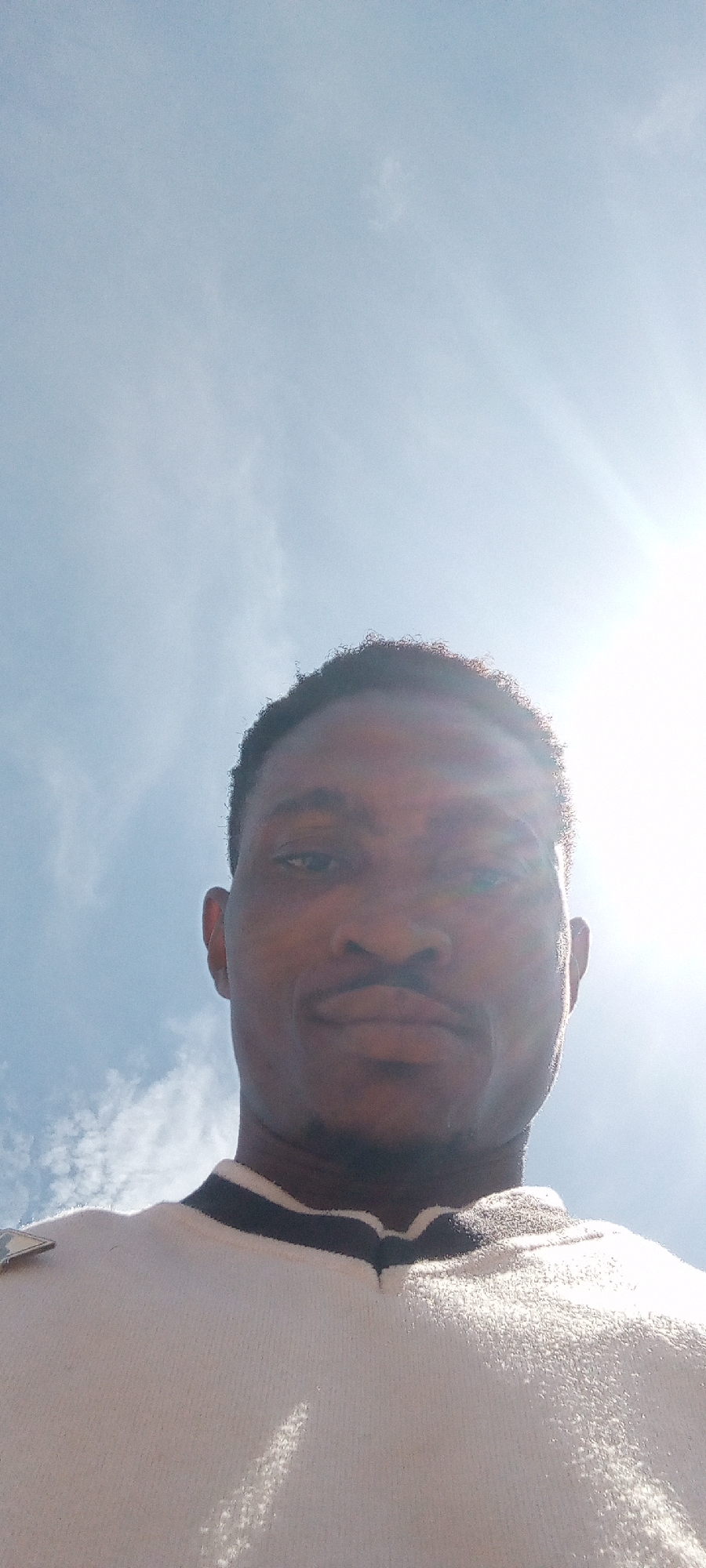 Man takes selfies under blue sky in Adankolo