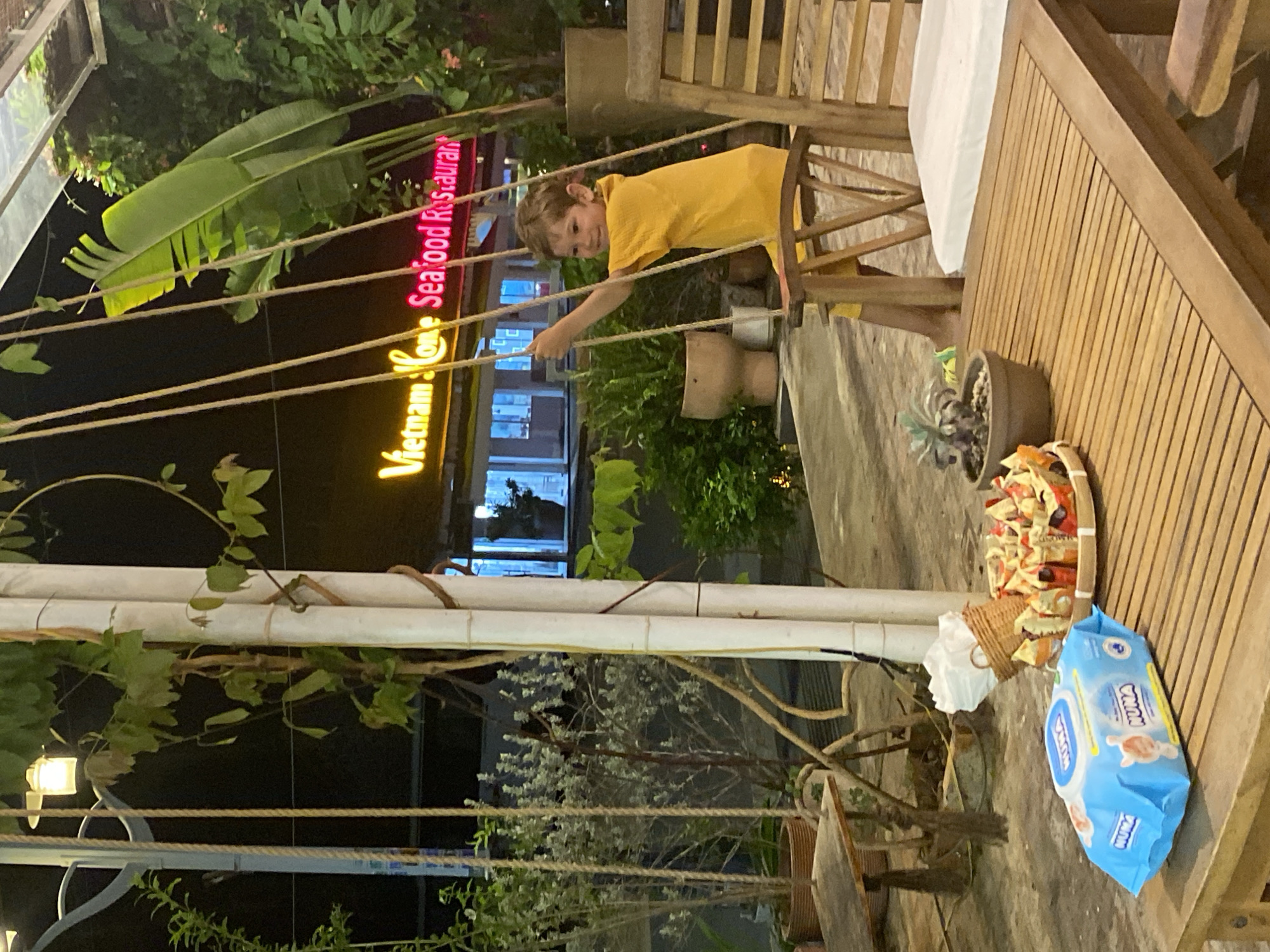 Kids on swings at a casual outdoor restaurant spot in Vietnam