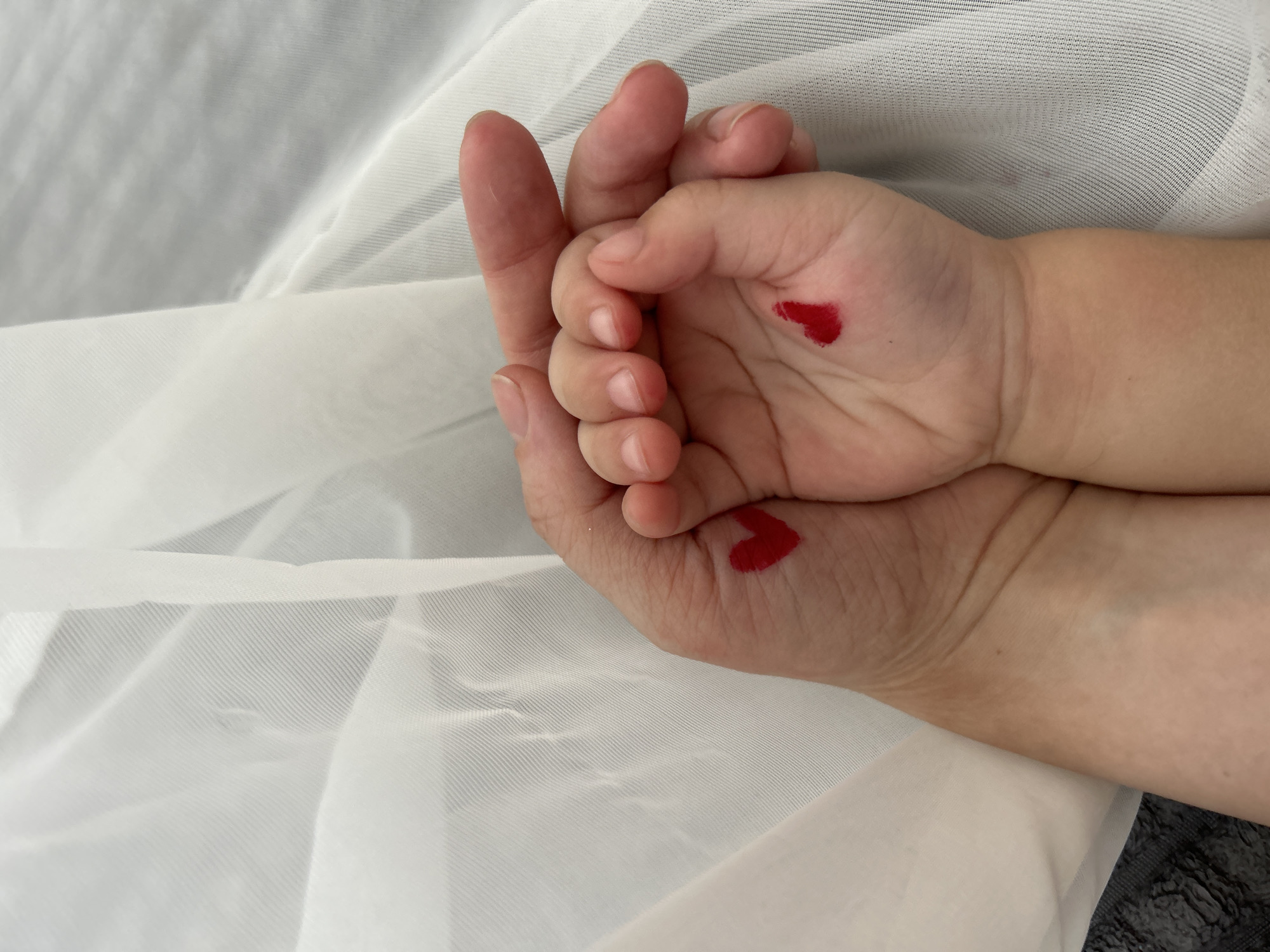 Adult, child hold hands with painted hearts in Ufa