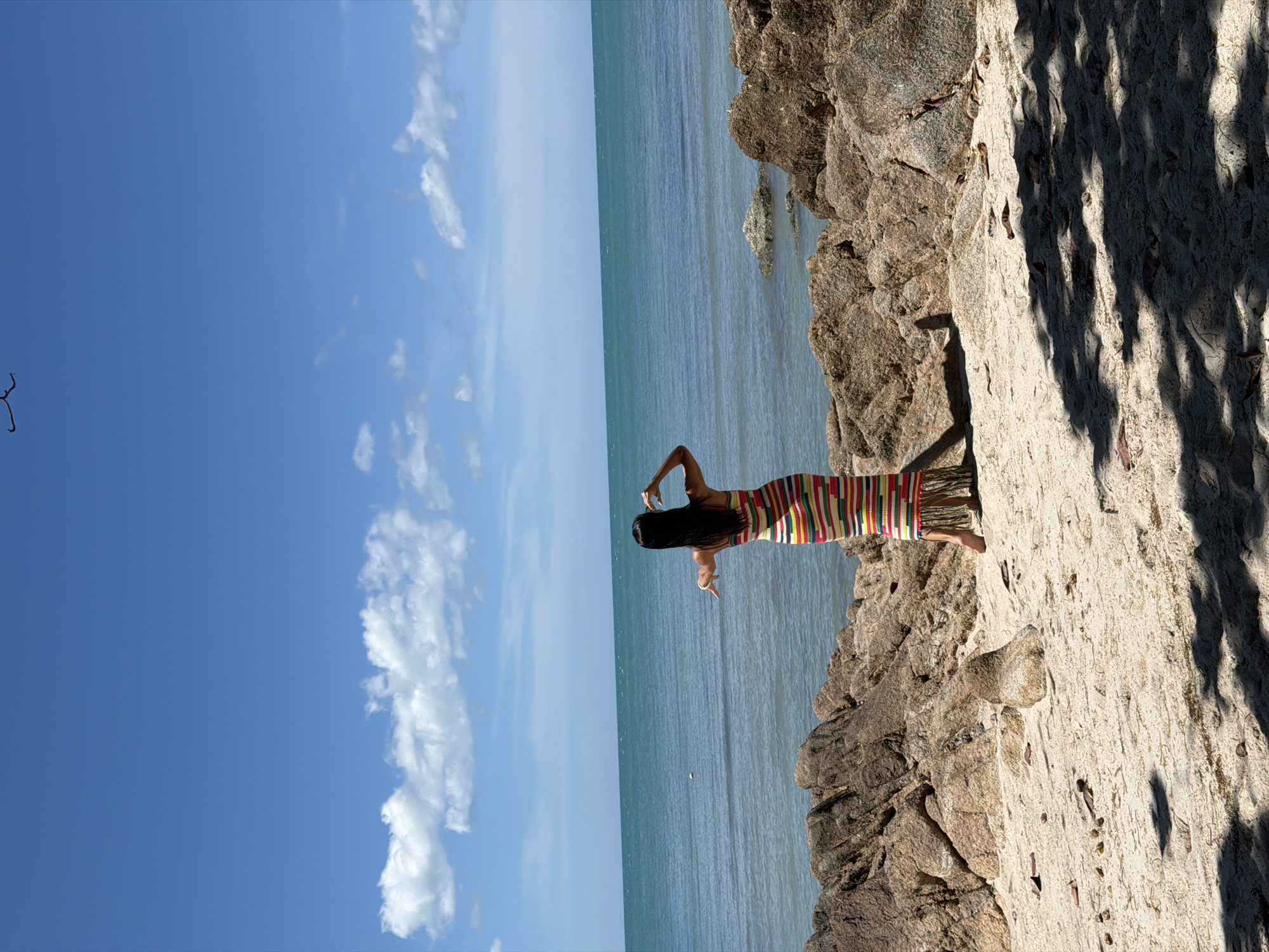 Lazy morning on a rocky Thai beach with boats and a swing