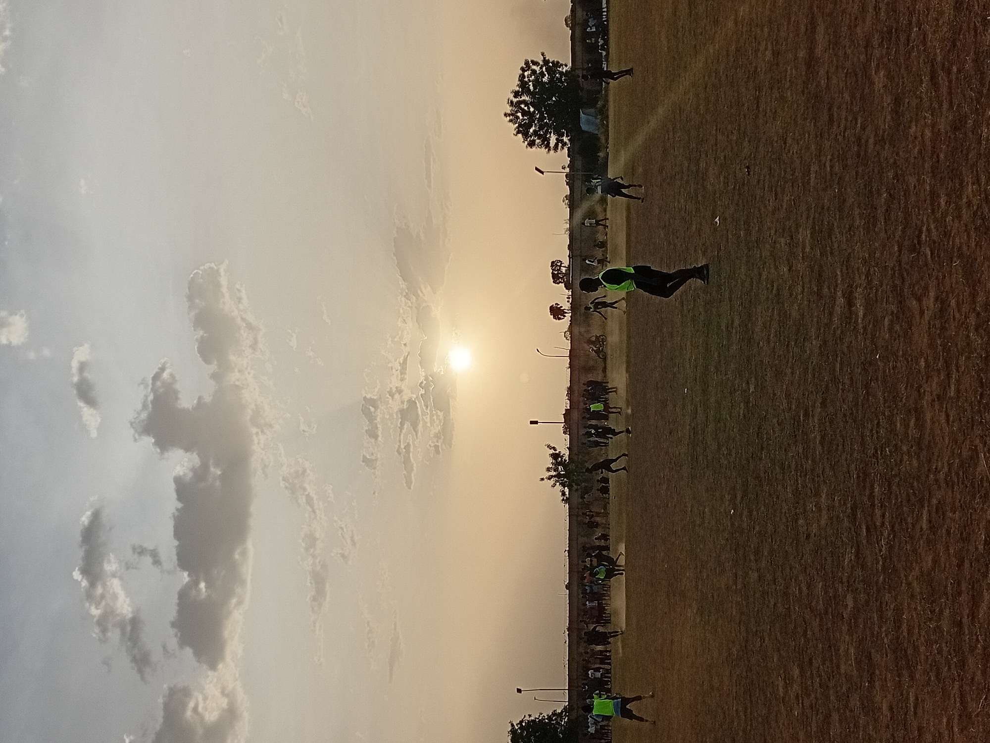 Sports field activity captured during golden hour sunset