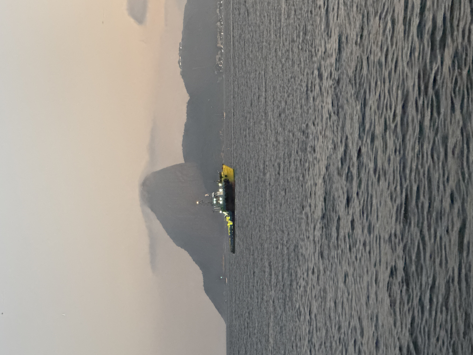 Drilling ship and tugboat off Niterói at twilight