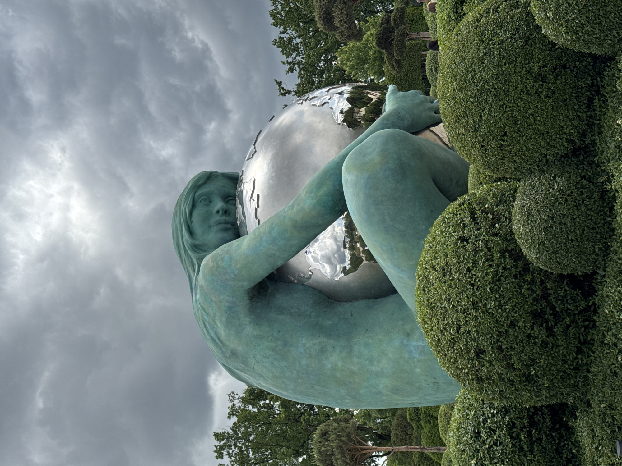 Weathered woman statue holding globe observed in Krasnodar, Russia