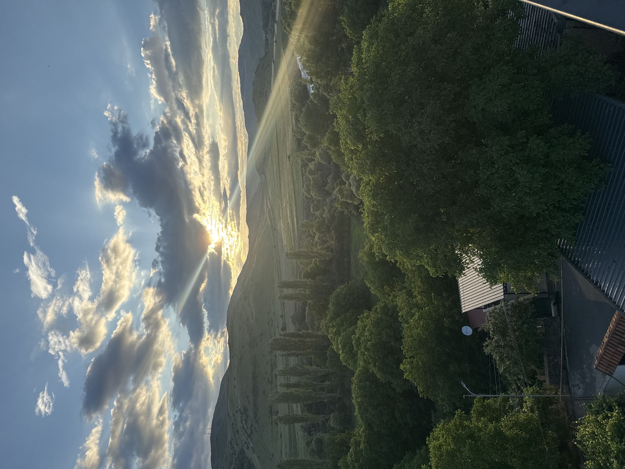 Golden hour light breaks over Aspindza's rooftops and stormy sky