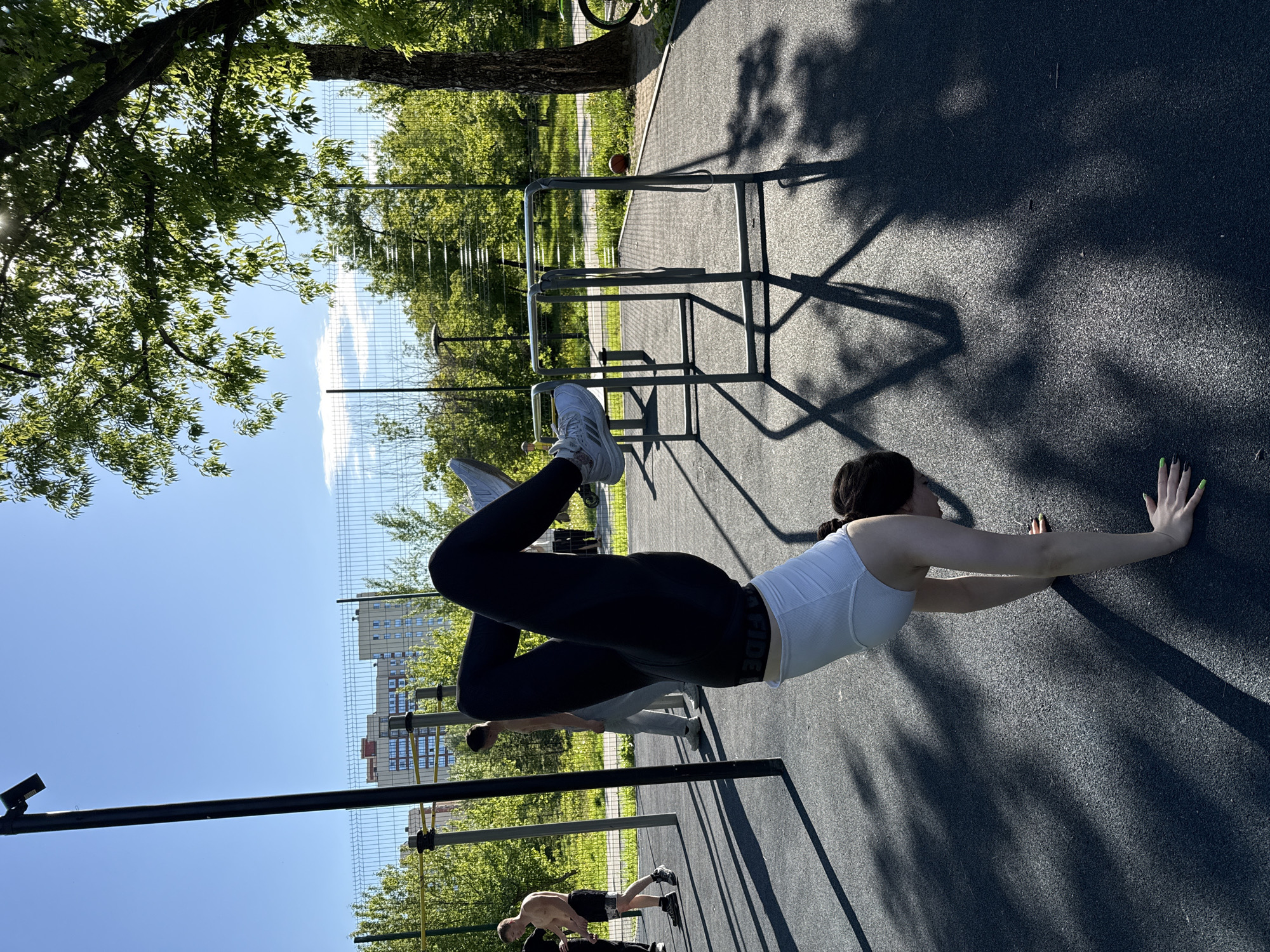 Woman performs varied workout routine at outdoor fitness park