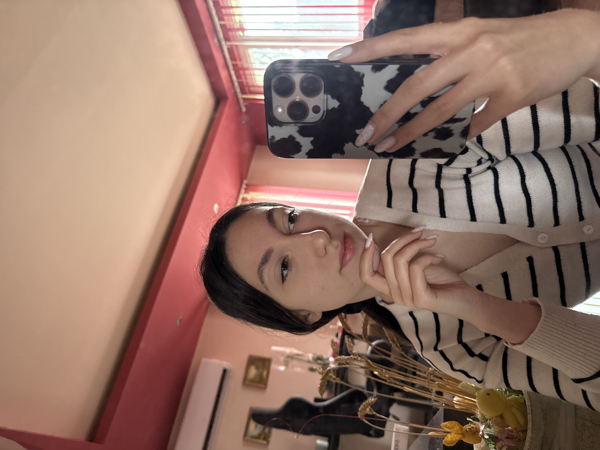 Woman takes mirror selfie in striped cardigan, Bulgaria