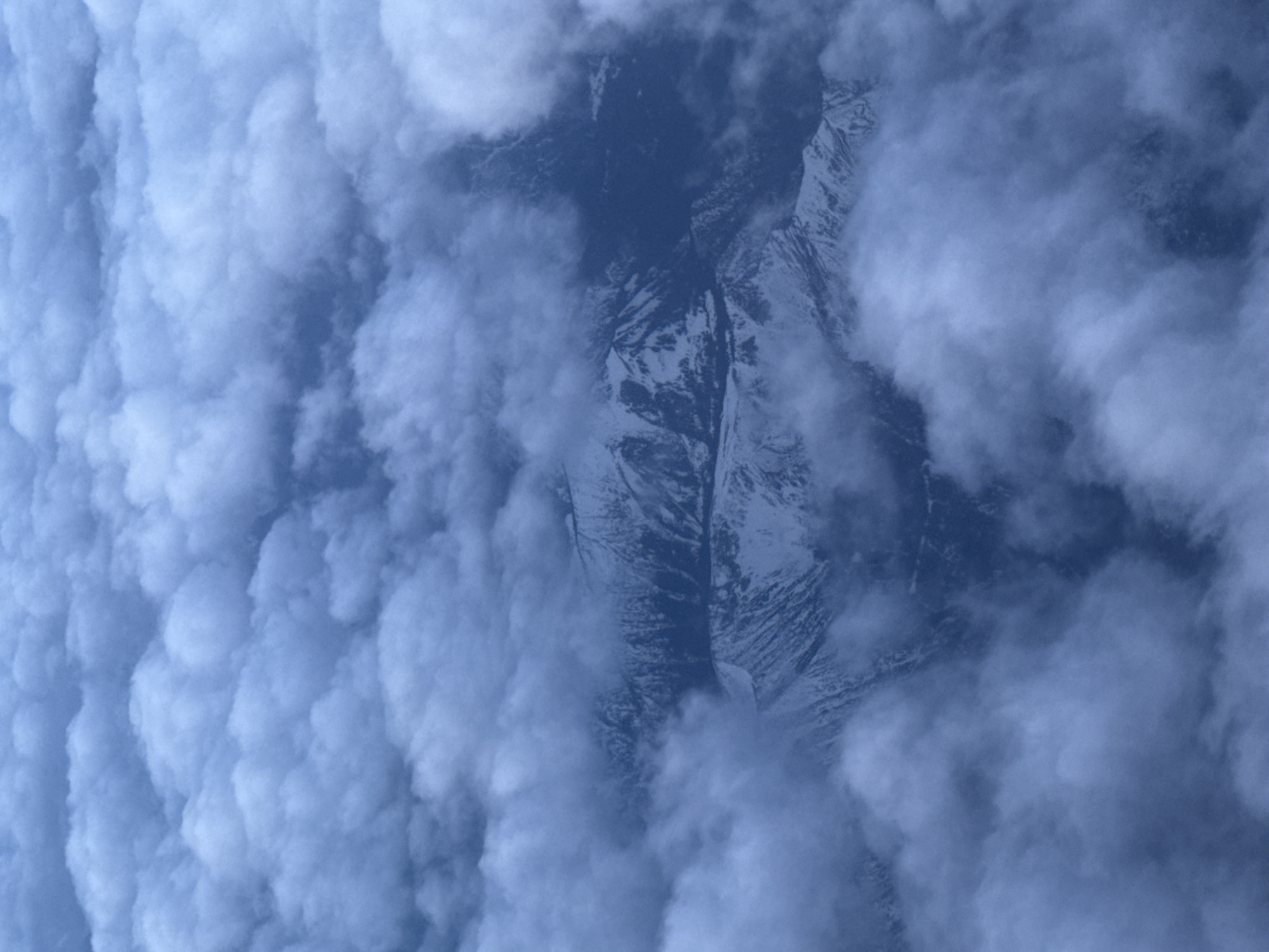 Early morning flight captures crescent moon over cloud-covered Sofia mountains