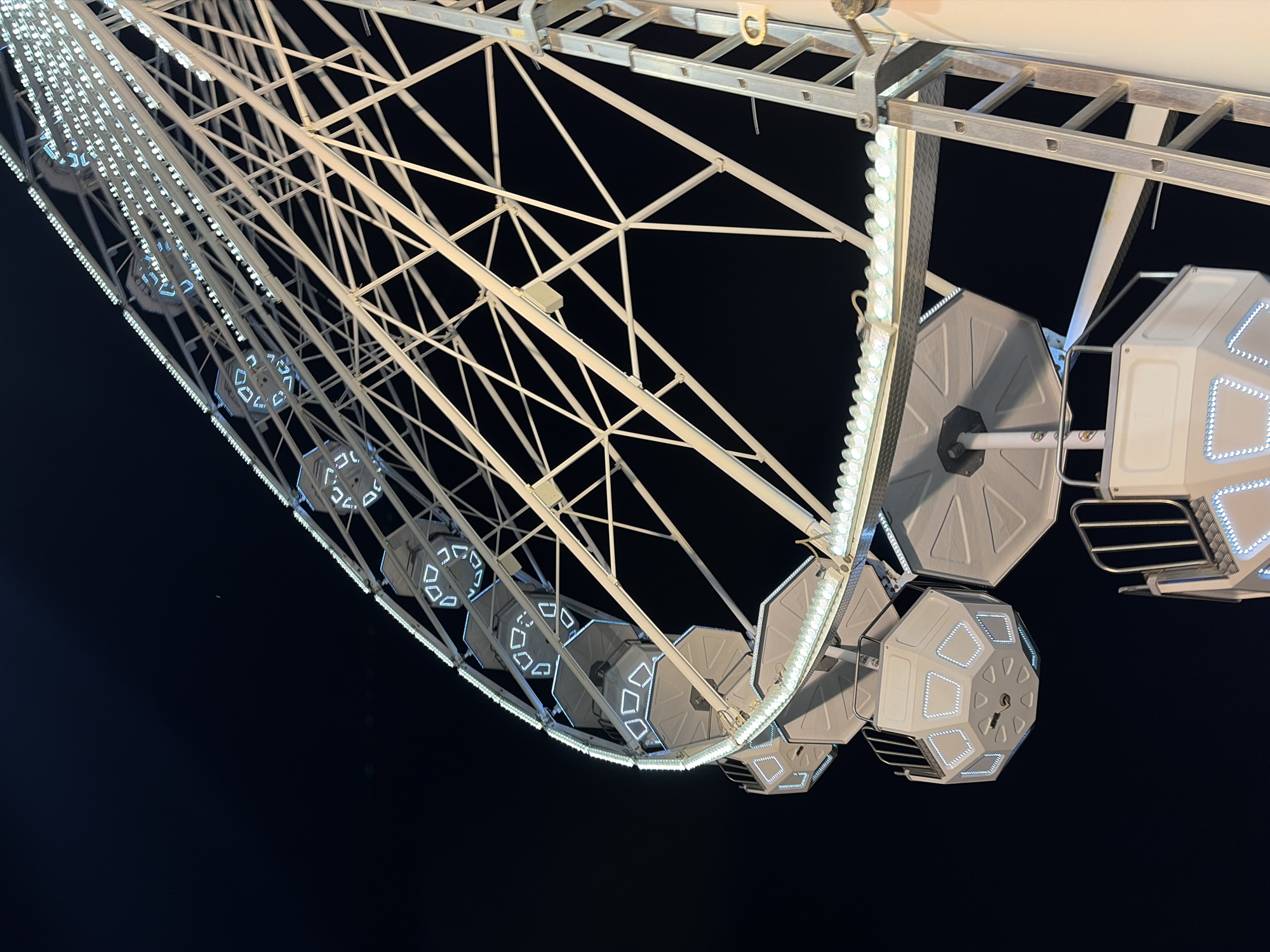 Ferris wheel glows with white and blue lights at night