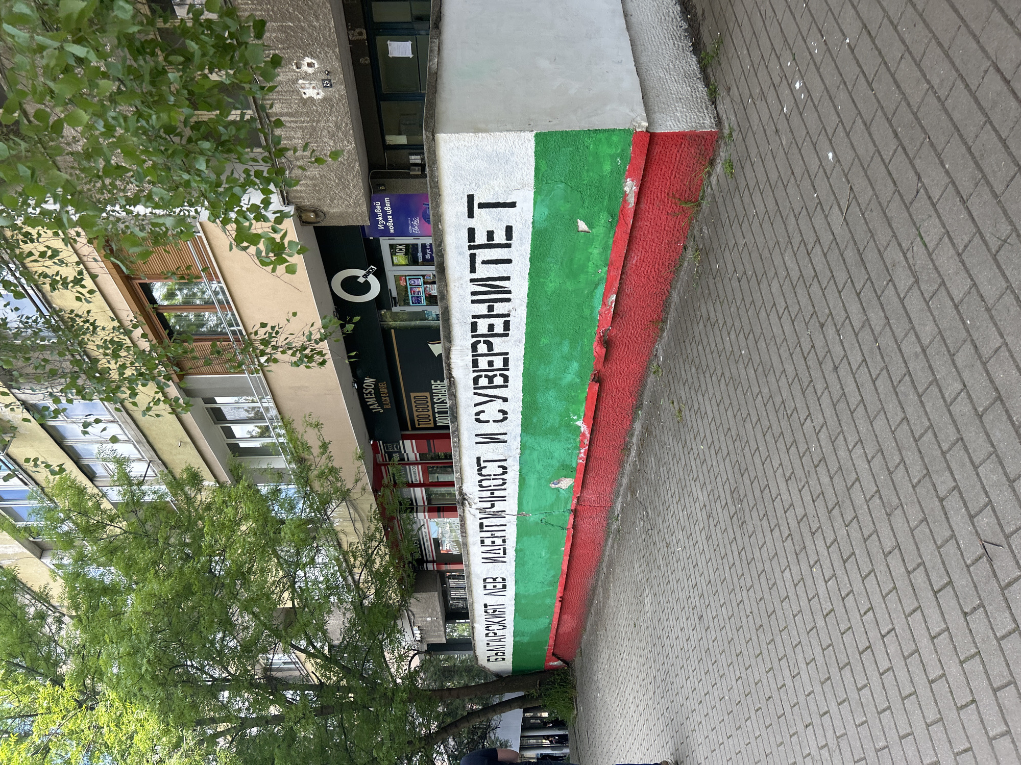 Building displays Bulgarian flag colors with Cyrillic text in Sofia