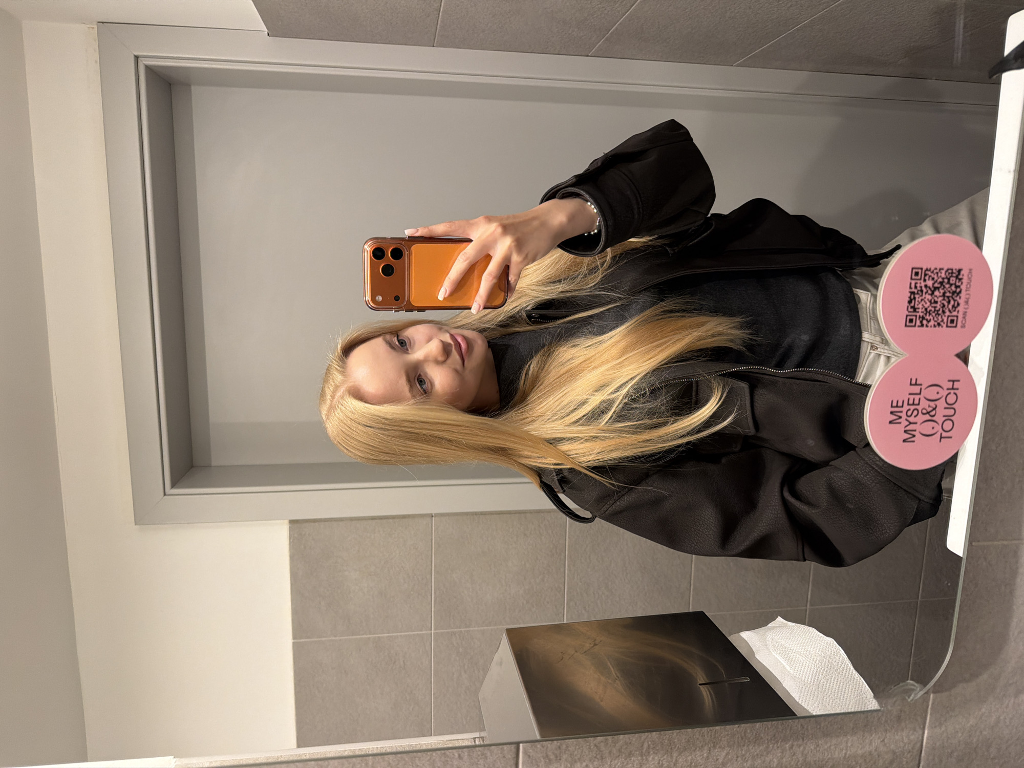 Woman takes selfies in restaurant bathroom during evening visit