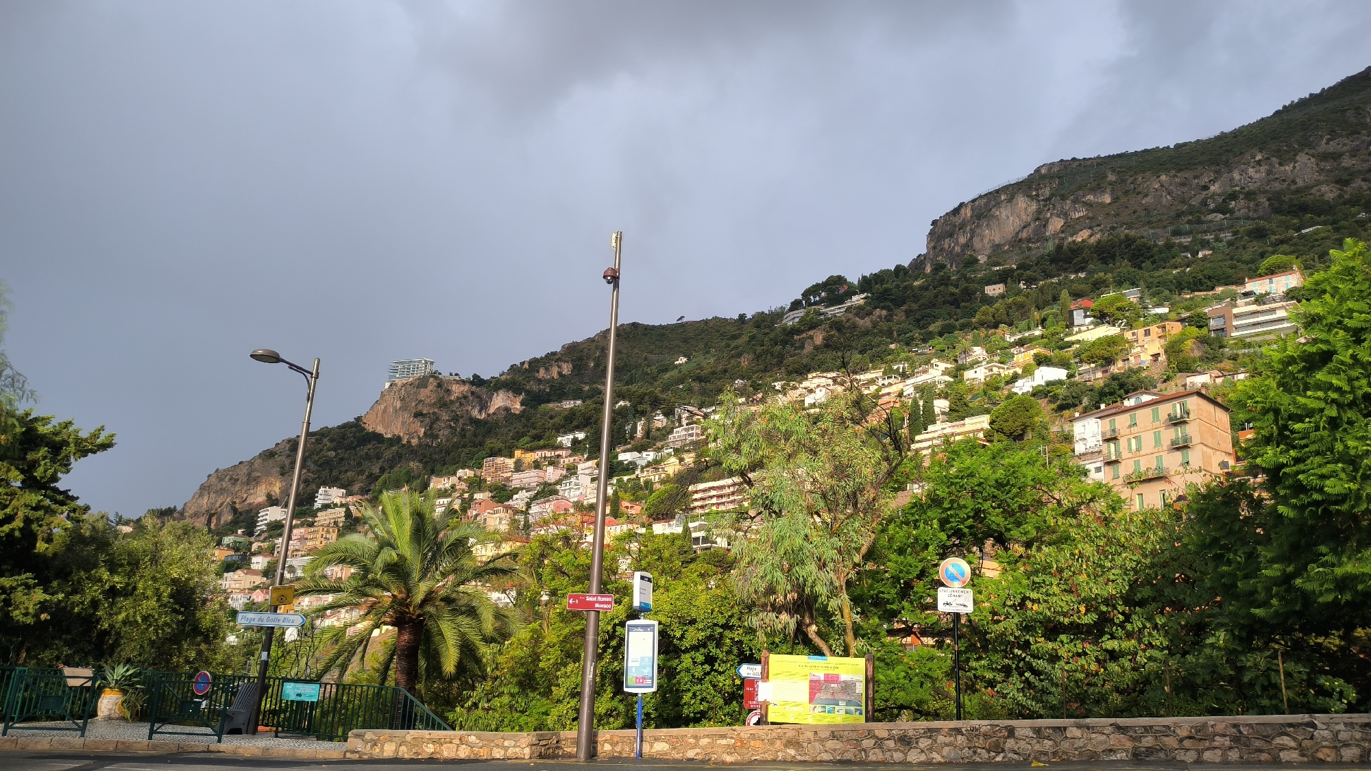 Rainbow over a foggy coastal hillside city after rain