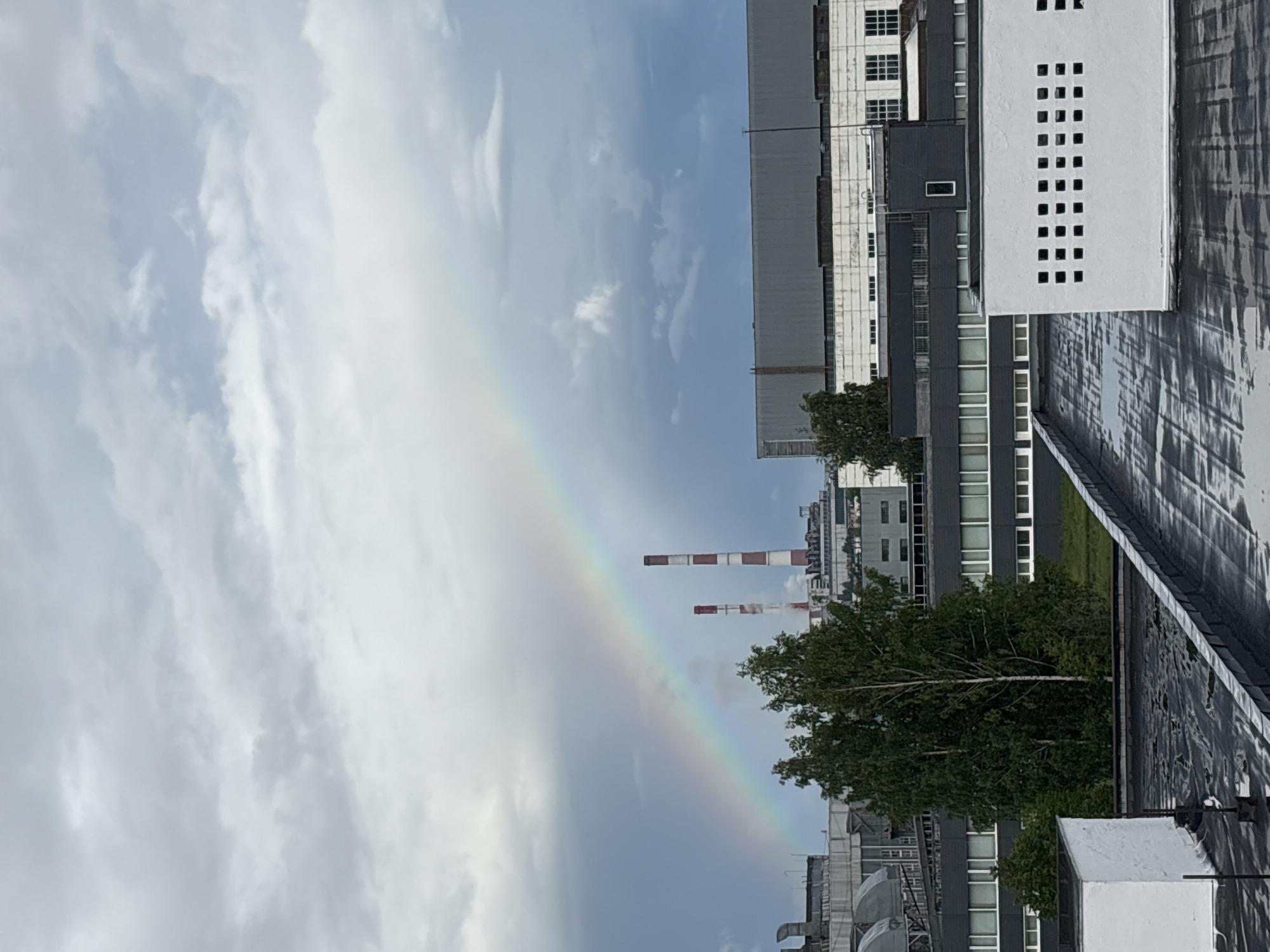 Rainbow brightens industrial Izhevsk skyline amid cloudy afternoon