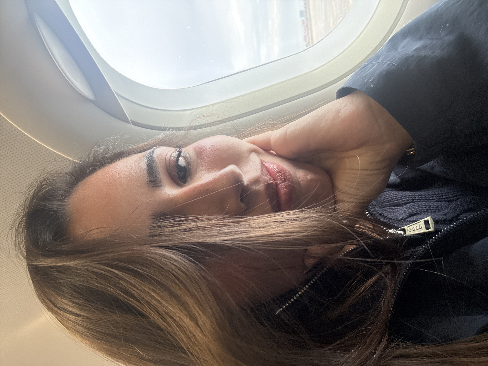Woman takes selfie in airplane window seat, San Antonio