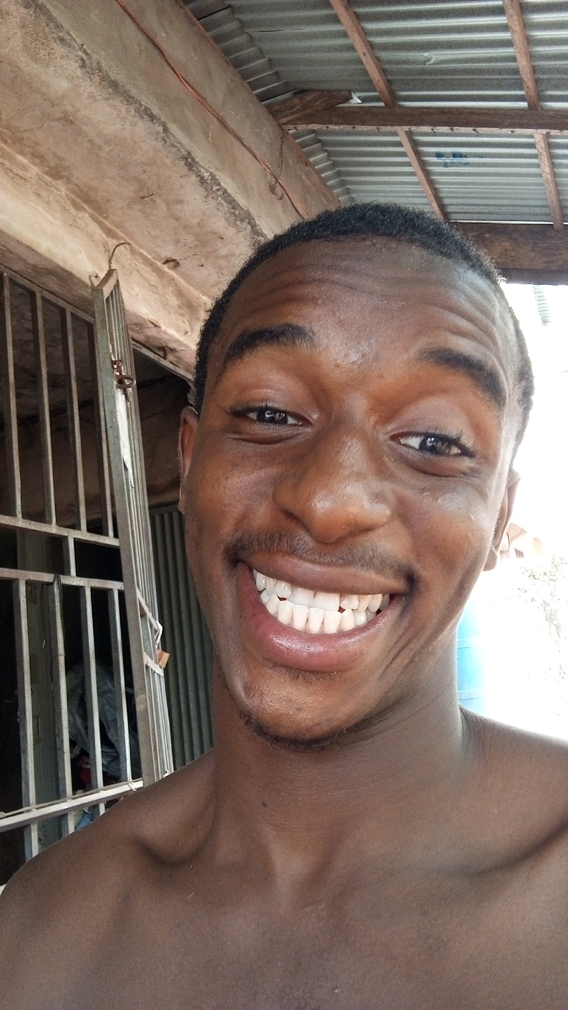 Young man takes smiling selfie at unknown location