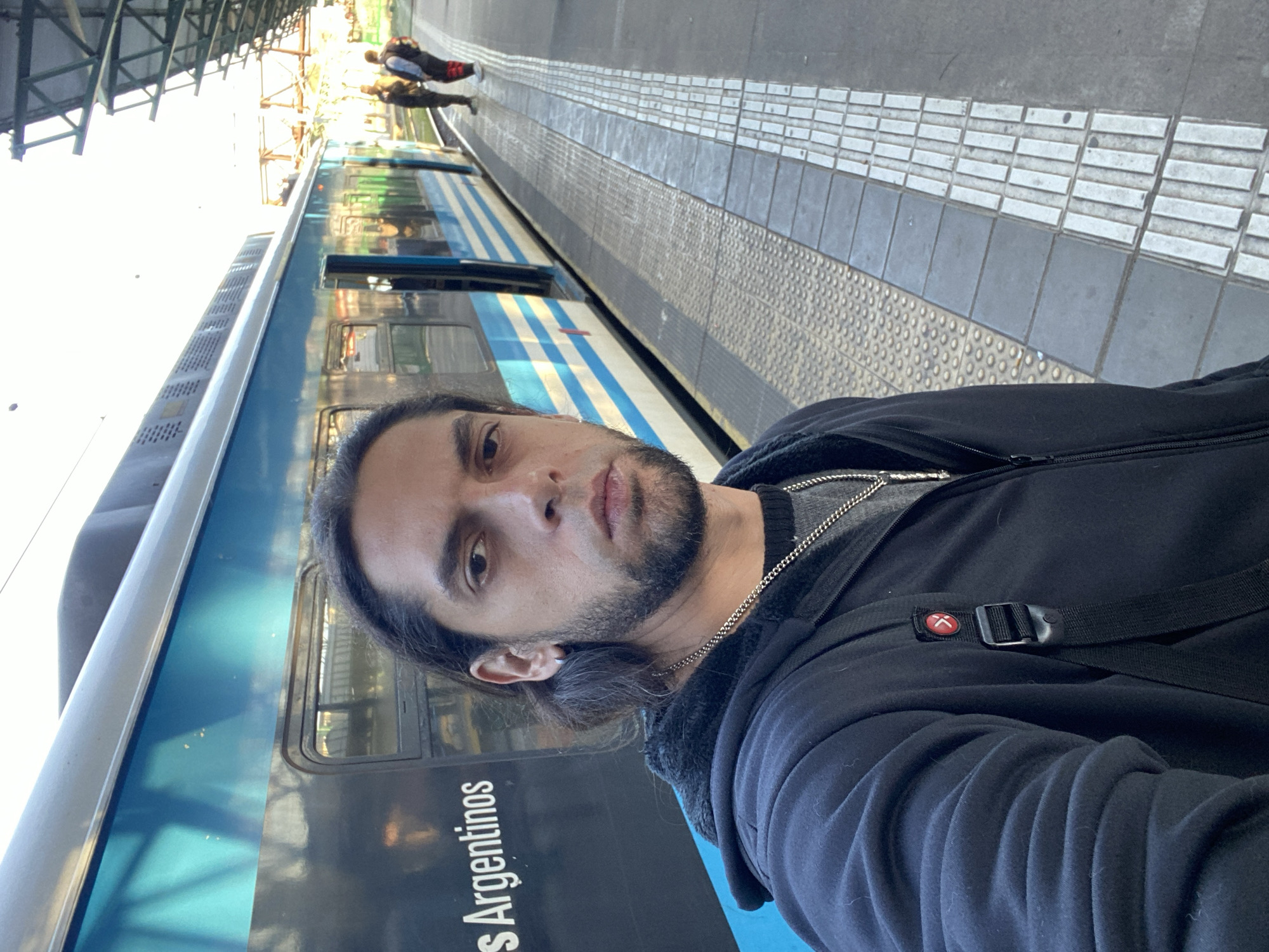 Man waits on Buenos Aires train platform evening rush
