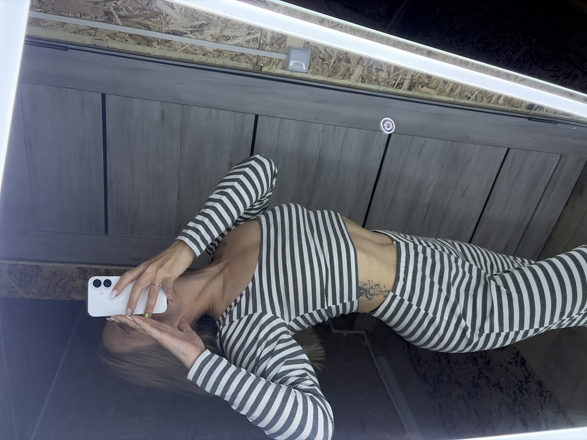 Woman takes selfies in wood-paneled room in Chaikovsky, Russia