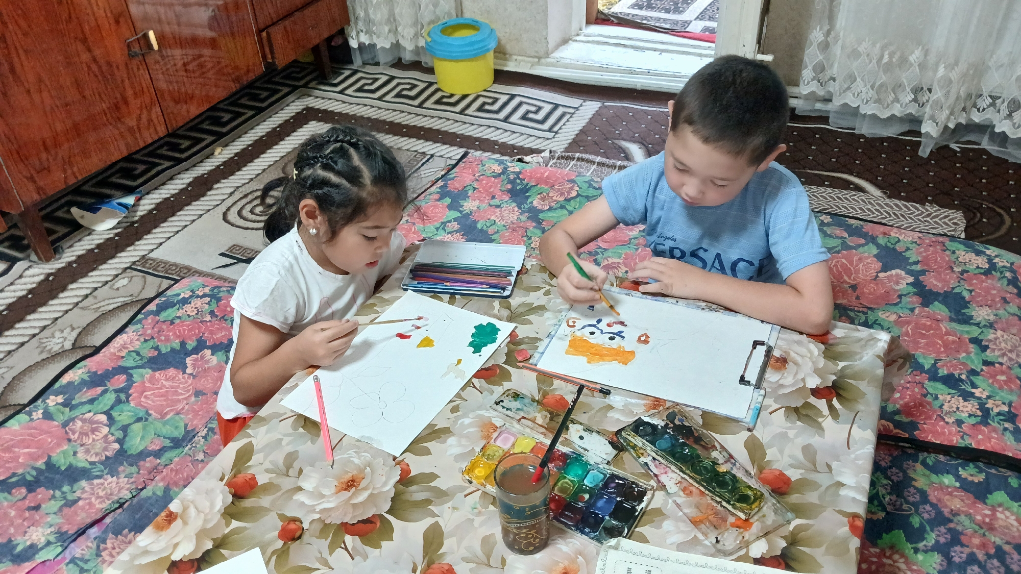 Kids painting and relaxing at home, trees outside