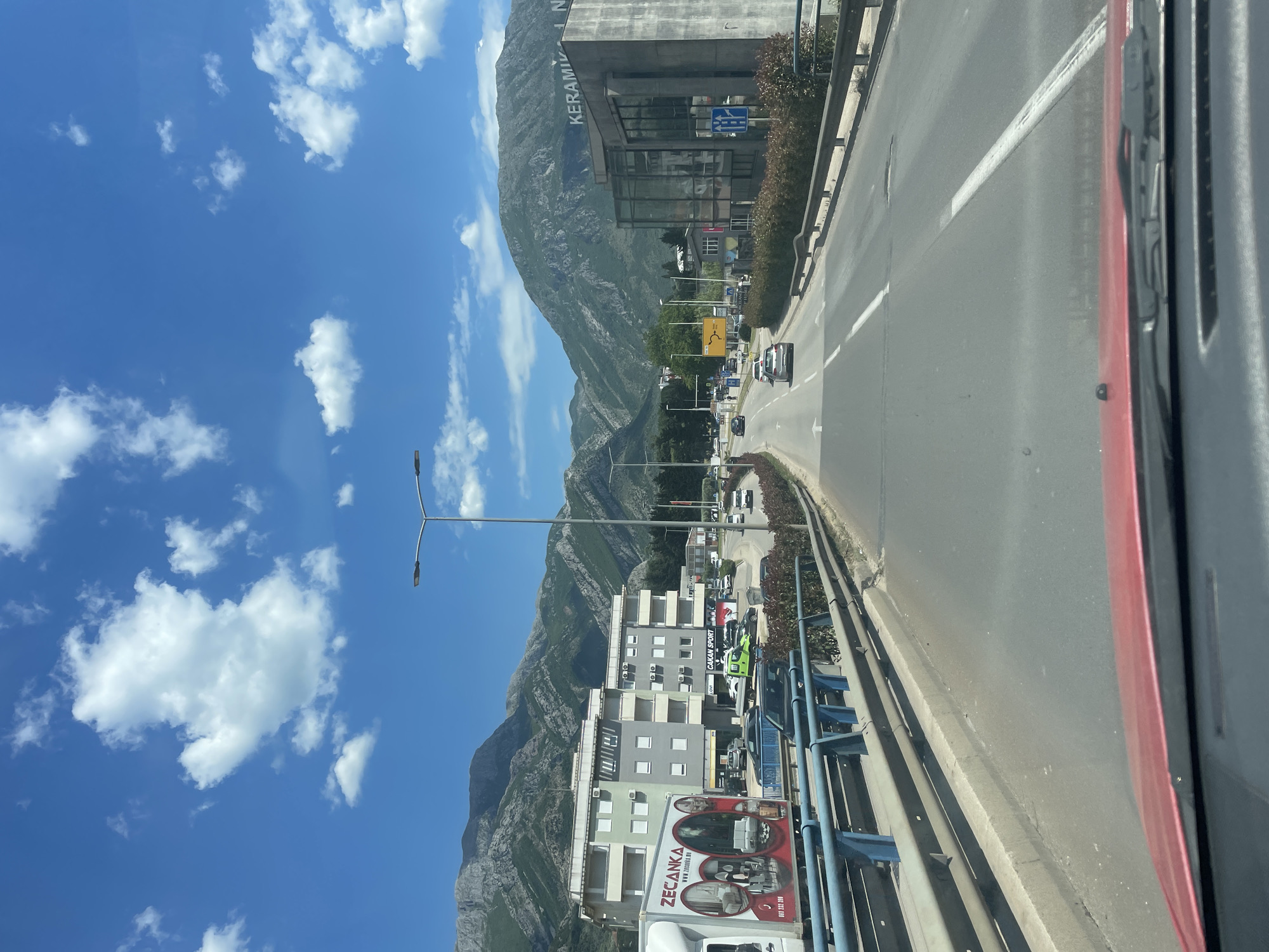 Road scene captured in Bjeliši, Montenegro showing mountains and ceramics building