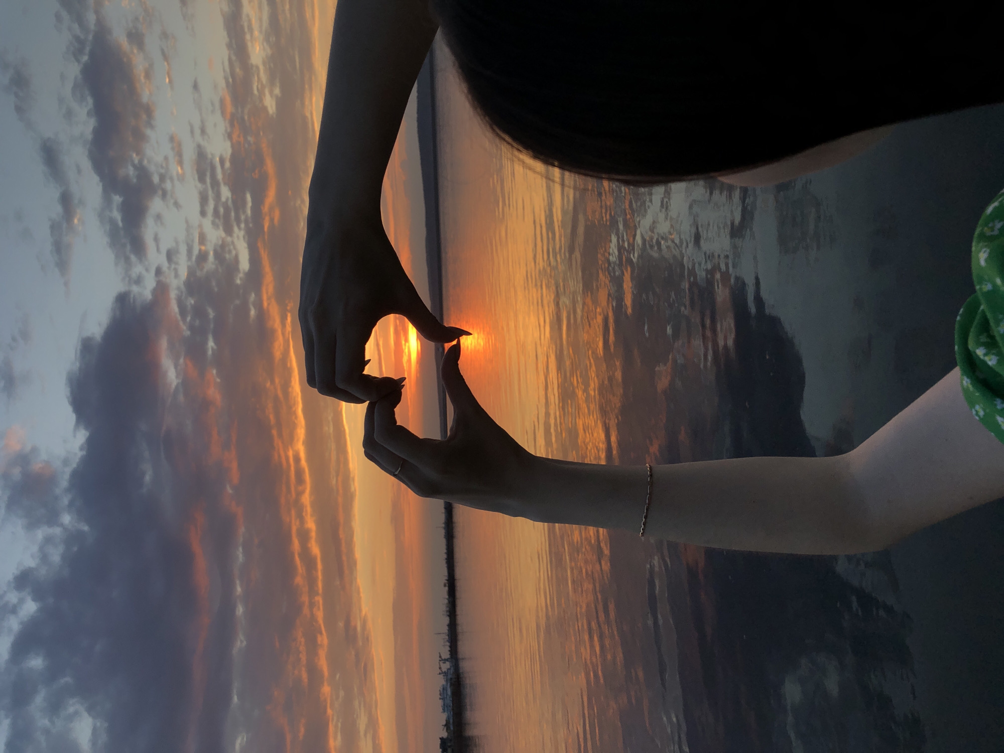 Woman photographs sunset moment along Kama River in Chaikovsky