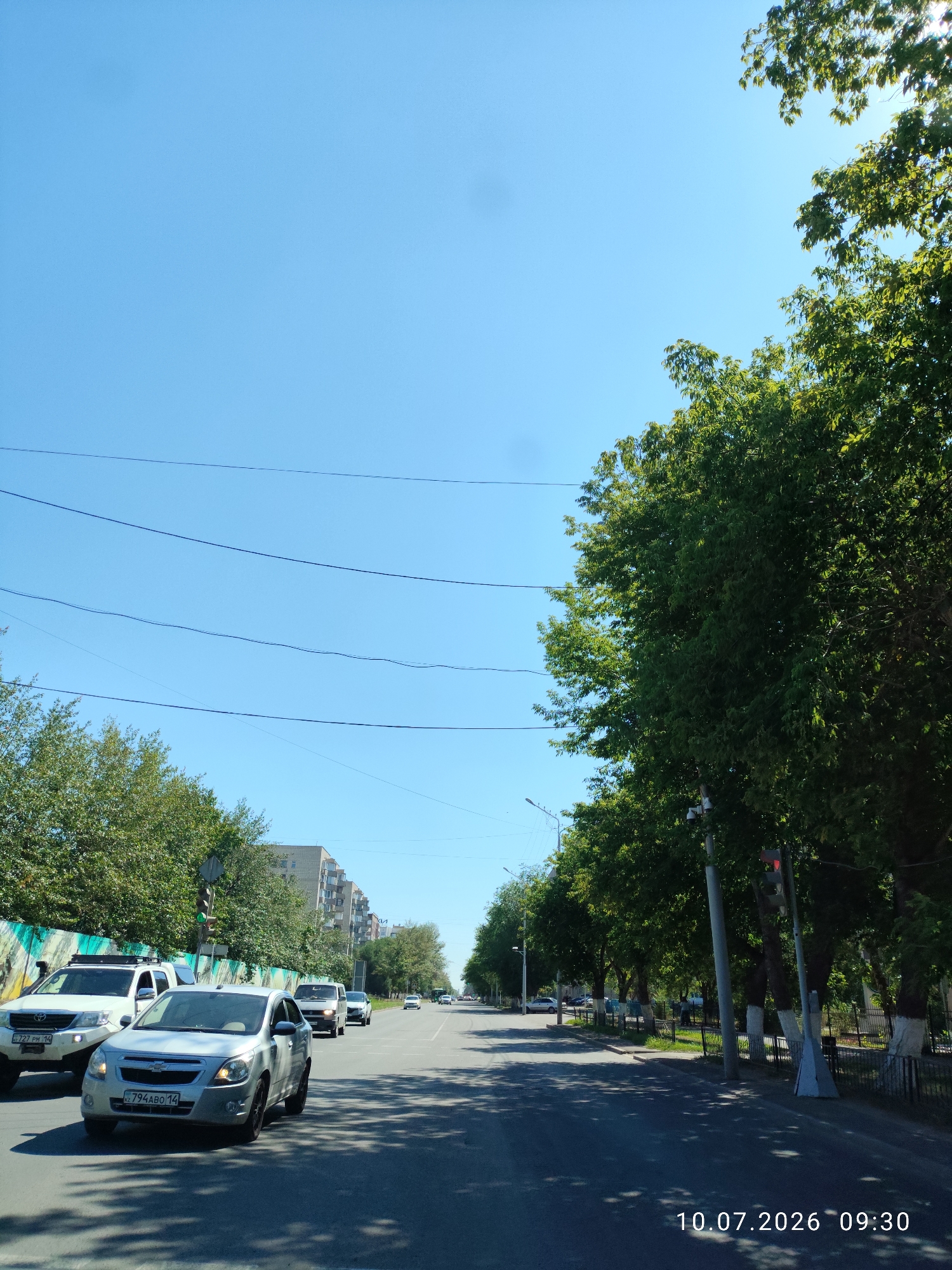 Driving through Pavlodar's tree-lined residential streets