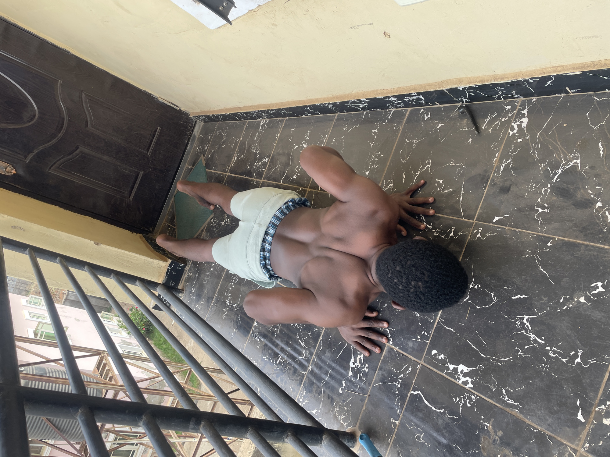 Man performs morning workout routine on Abuja balcony