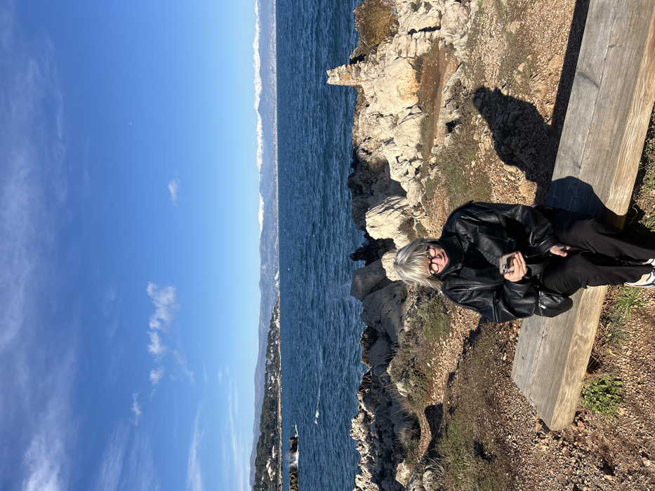 Woman photographs scenic coastal walk in Antibes, France