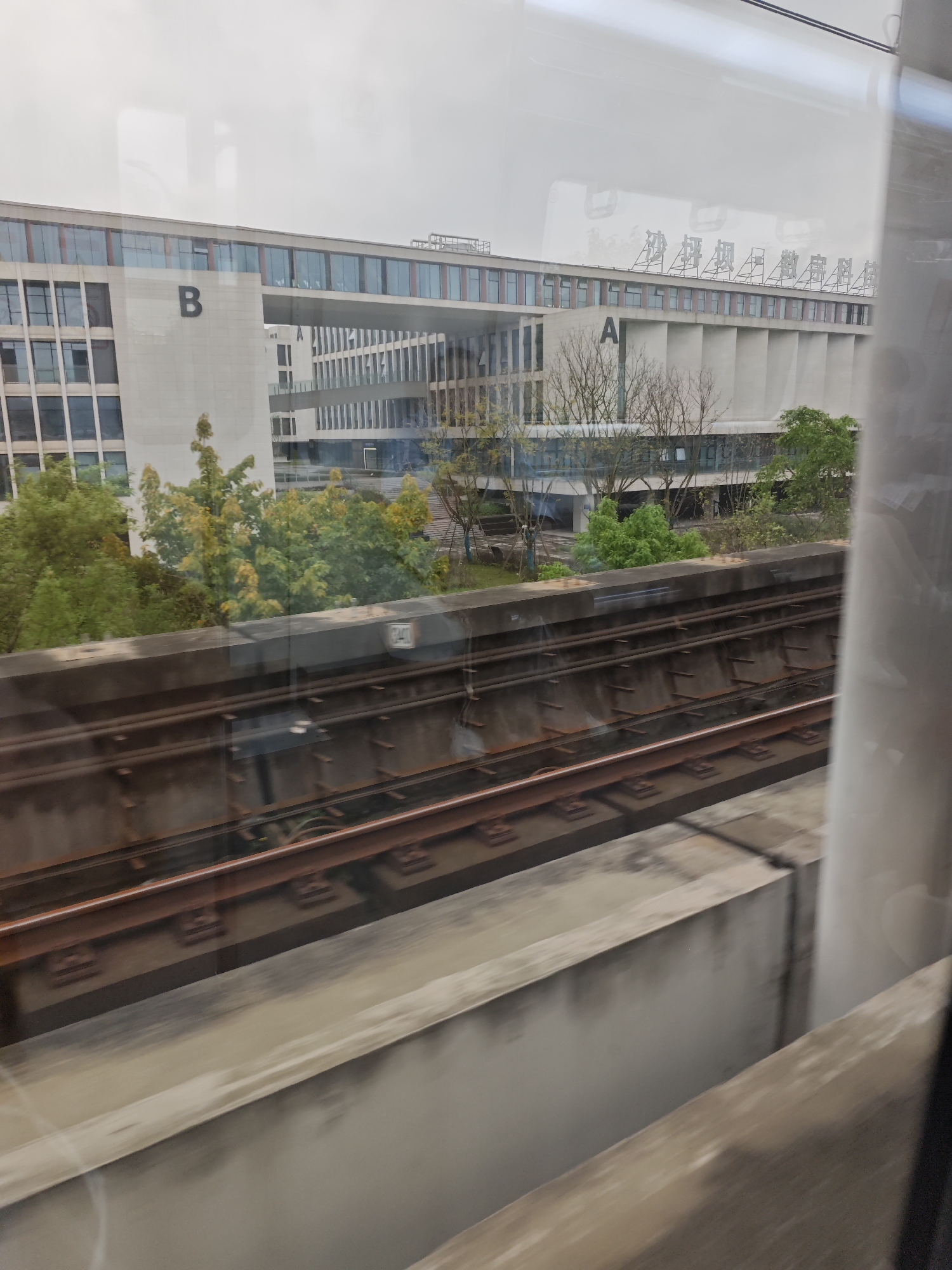 Train passenger photographs modern building complex in Shapingba District